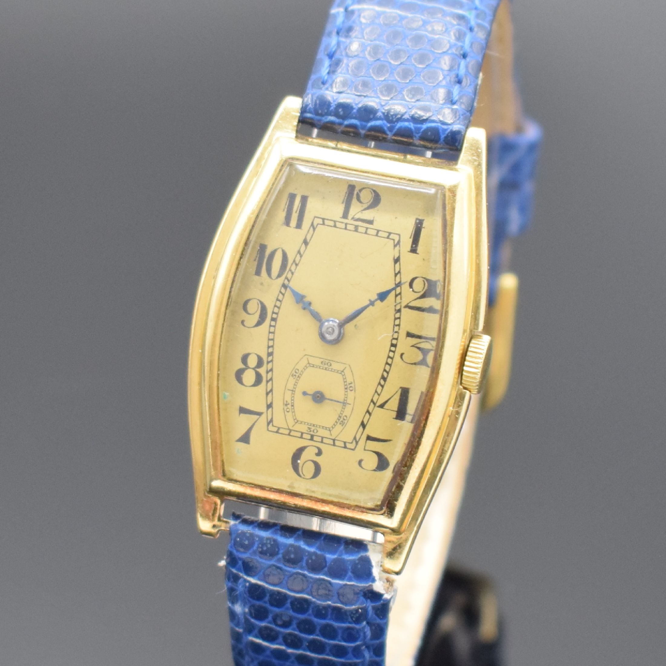 Detail a: Frühe tonneauförmige Armbanduhr in GG 750/000, Schweiz um 1925, Handaufzug, Scharniergeh., gold. Zifferbl. m. arab. Zahlen, gebl. Zeiger, Ankerwerk ...