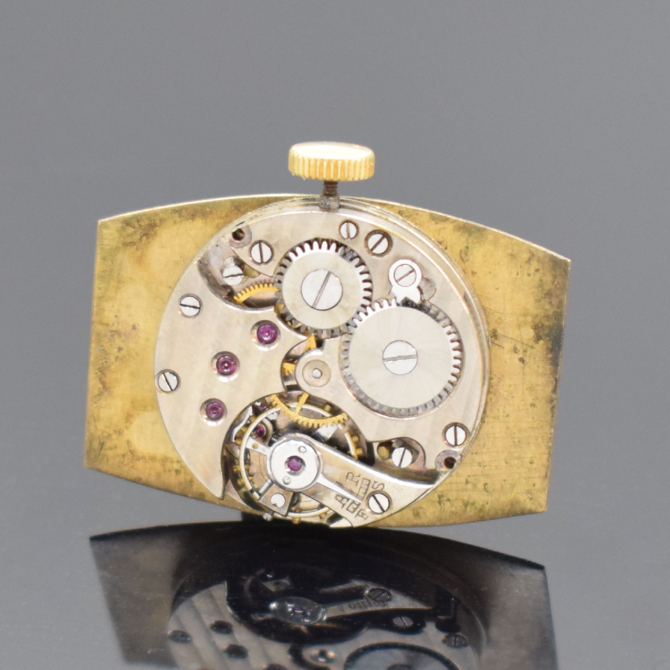 Detail d: Frühe tonneauförmige Armbanduhr in GG 750/000, Schweiz um 1925, Handaufzug, Scharniergeh., gold. Zifferbl. m. arab. Zahlen, gebl. Zeiger, Ankerwerk ...