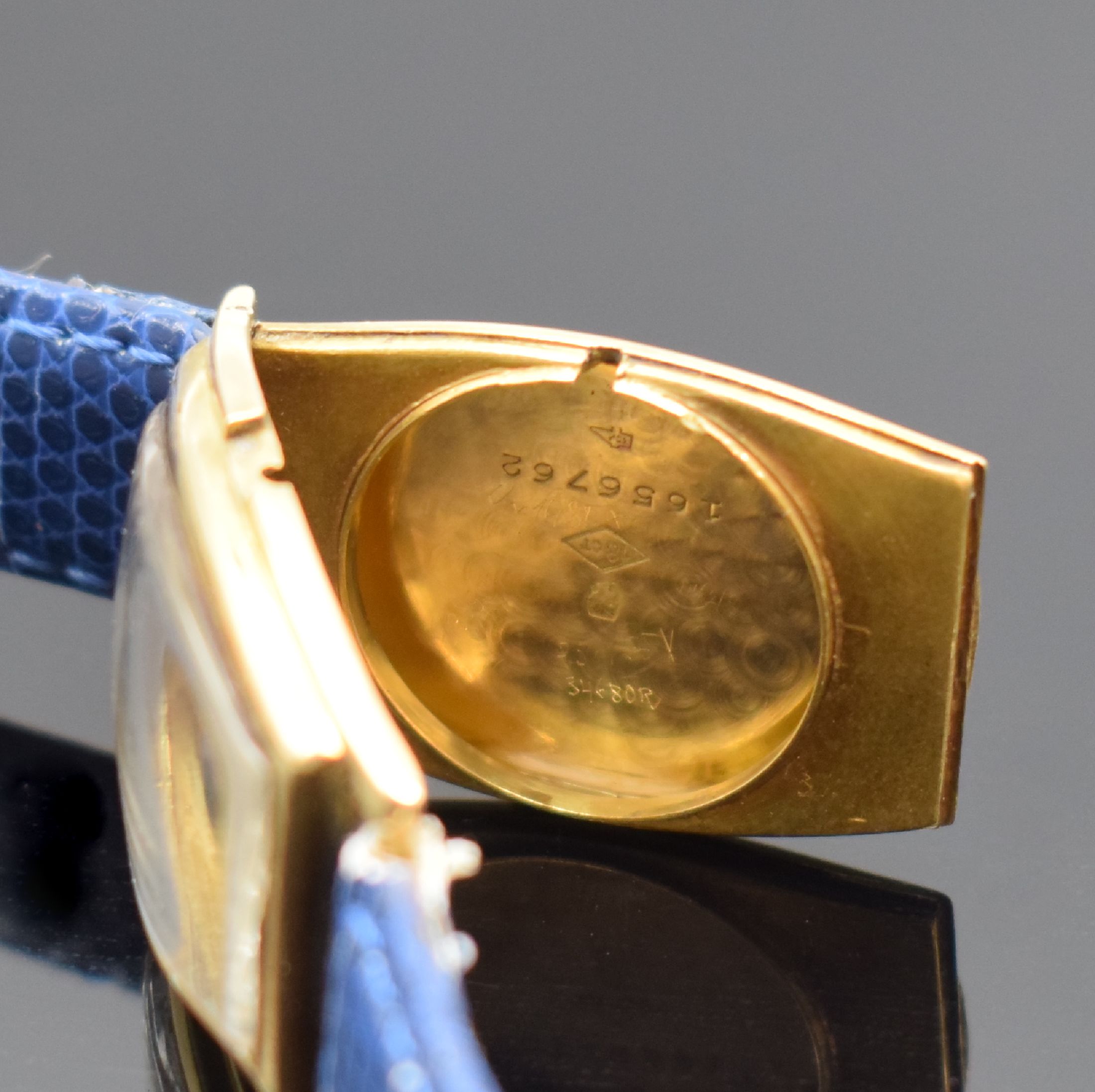 Detail e: Frühe tonneauförmige Armbanduhr in GG 750/000, Schweiz um 1925, Handaufzug, Scharniergeh., gold. Zifferbl. m. arab. Zahlen, gebl. Zeiger, Ankerwerk ...