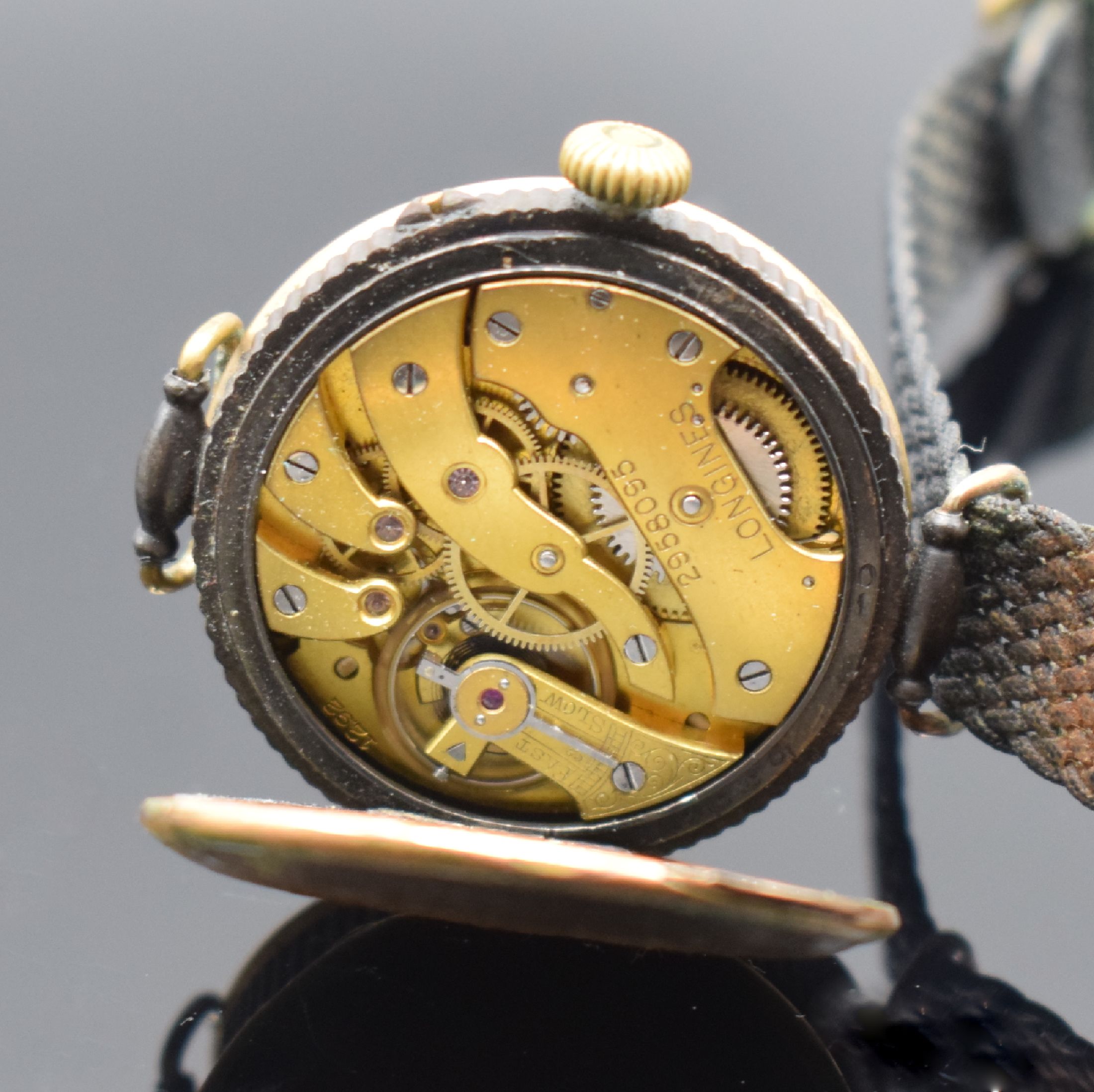 Detail e: LONGINES frühe Herrenarmbanduhr, Handaufzug, Schweiz um 1914, brüniertes Geh., Scharnierboden altersbed. oxidiert/rost., Cuv. m. Schriftzug ...