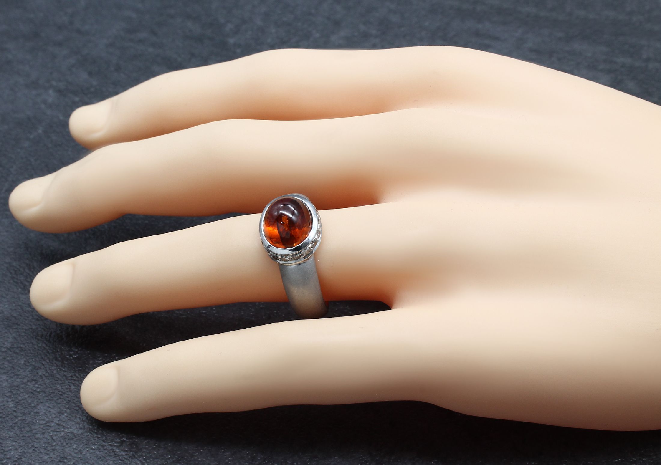 Detail b: 18 kt Gold Granat-Brillant-Ring, WG 750/000 gepr., mittig Granat-Cabochon ca. 3.0 ct, umgeben von 18 Brillanten zus. ca. 0.36 ctWeiß/si, ...