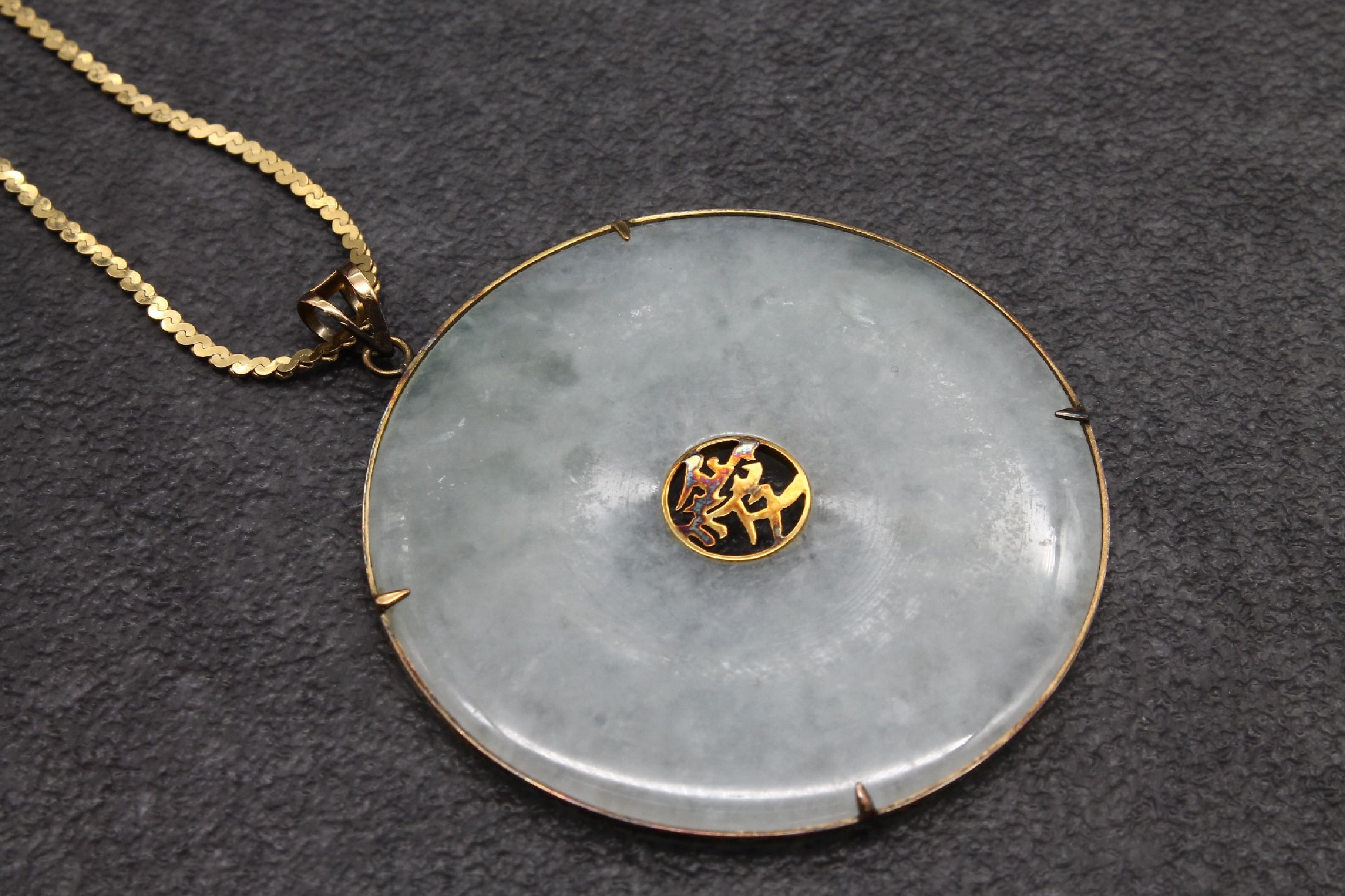 Detail a: Konvolut mit Jade: Pi-Scheibe Fassung und Kette 14 kt Gold, GG 585/000, Durchm. ca. 4.7 cm, L ca. 52 cm und Armreif mit GG 585/000-Montur, Durchm. ...
