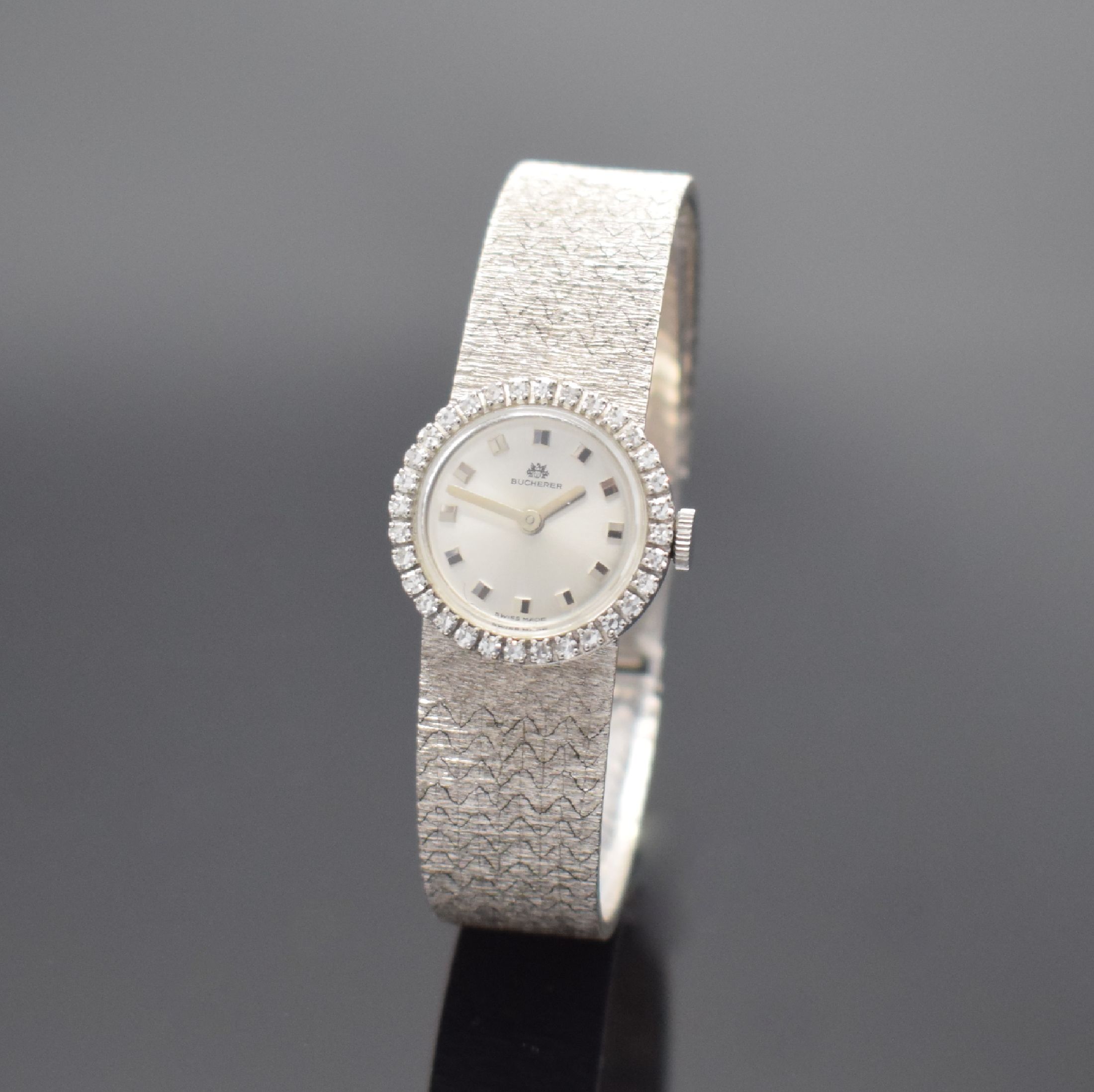 BUCHERER Damenarmbanduhr in WG 750/000 mit Diamanten, Schweiz um 1965, Handaufzug, 2- teil. Geh., Boden aufgedr., Lünette m. Diamanten bes., silb. ...