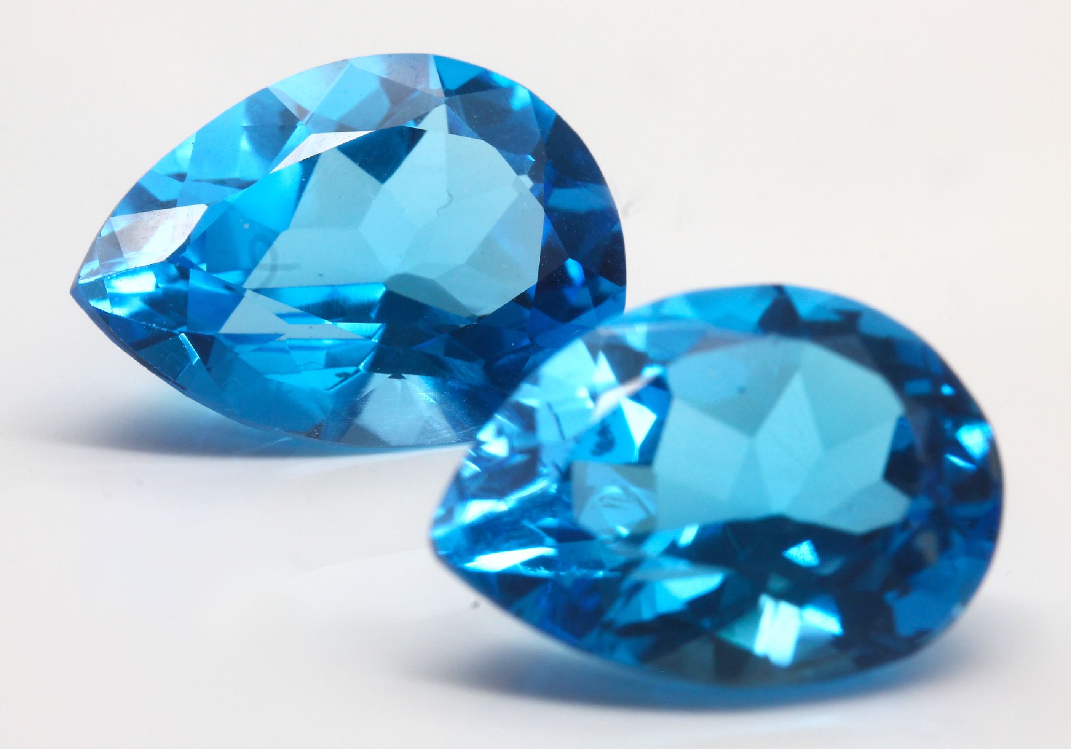 Detail a: Loses Blautopas-Pärchen zus. ca. 34.65 ct, facett. Tropfen, intensives Blau, beh.