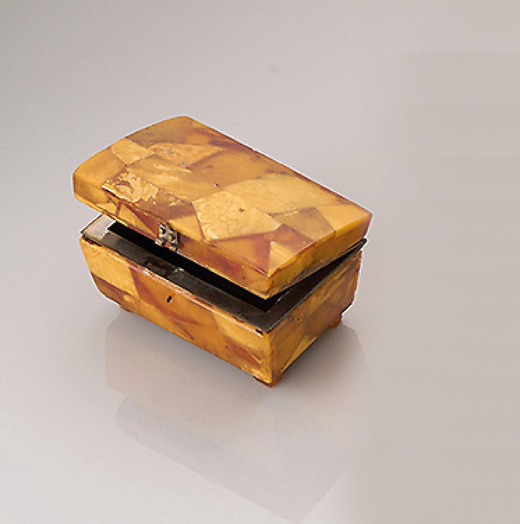 Kleine Bernstein-Truhe, wohl Königsberg um 1925/30, Bernsteinplatten in versch. Größen, Formen und Farben aneinander gefügt, Bernstein mit nat. ...