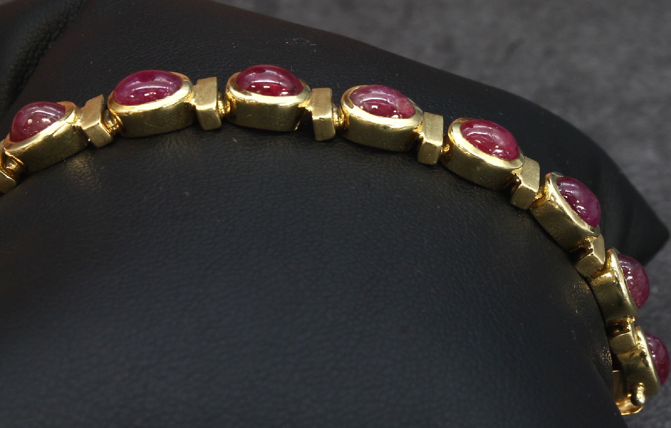 Detail d: 14 kt Gold Rubin-Armband, GG 585/000, z.T. matt., 16 Rubincabochons zus. ca. 21.00 ct, L.ca. 18 cm, 31.7 g, Kastenschloss mit Sicherheitsachten