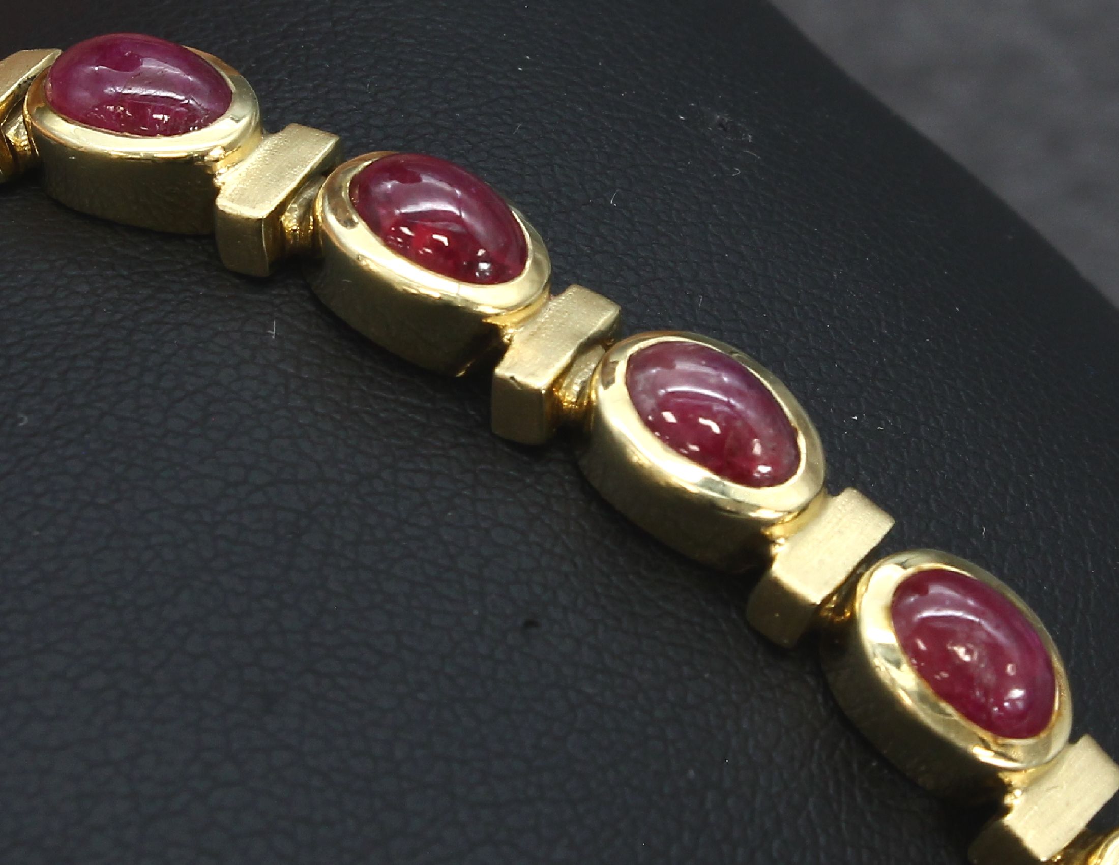 Detail e: 14 kt Gold Rubin-Armband, GG 585/000, z.T. matt., 16 Rubincabochons zus. ca. 21.00 ct, L.ca. 18 cm, 31.7 g, Kastenschloss mit Sicherheitsachten