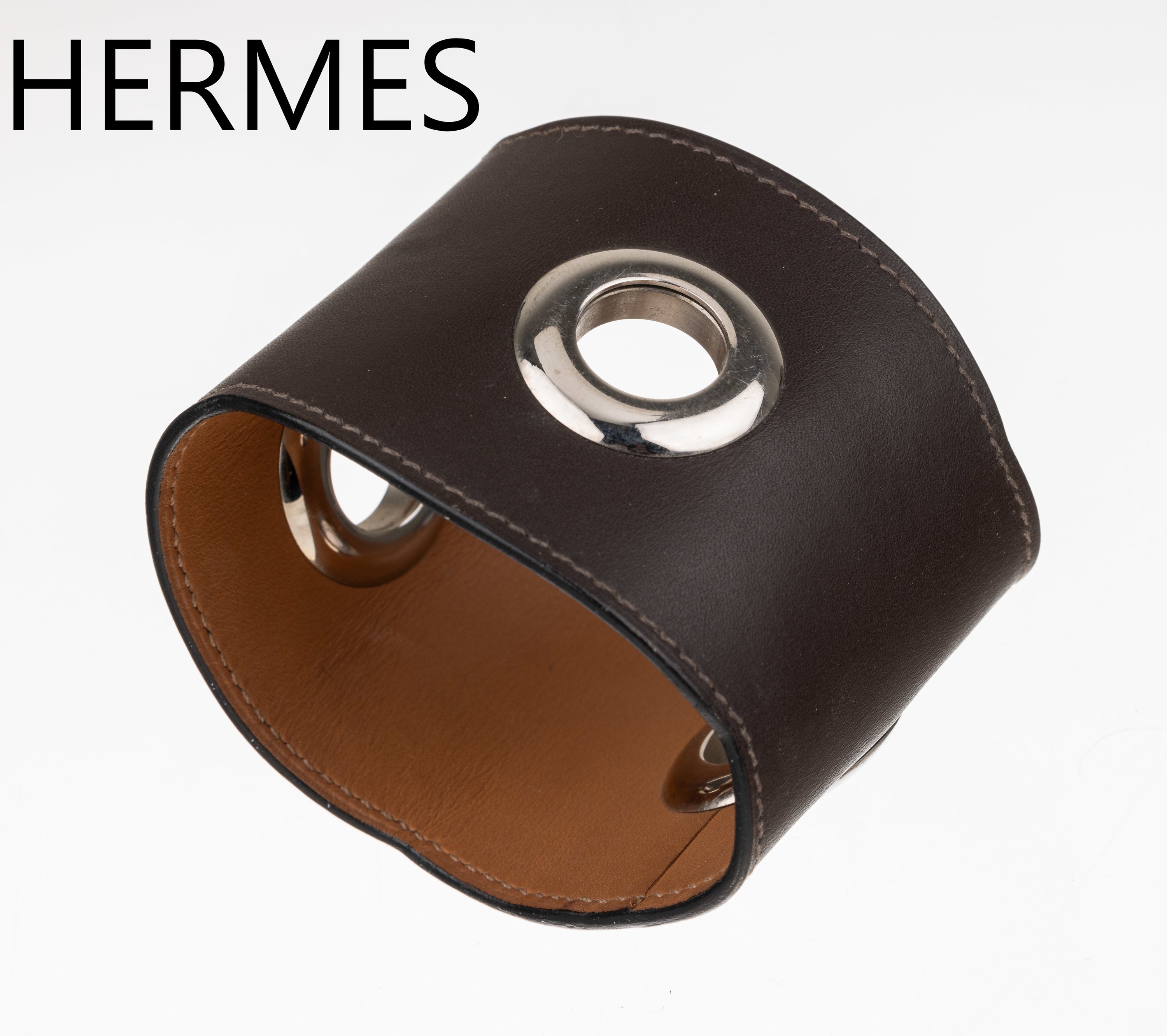 HERMES Lederarmreif, dunkelbraunes Leder mit 3 Chromringen, Rand mit leichtem Wellendekor, Durchm. ca. 6.5 cm, B. ca. 5.8 cm, HERMES Paris, Made in ...