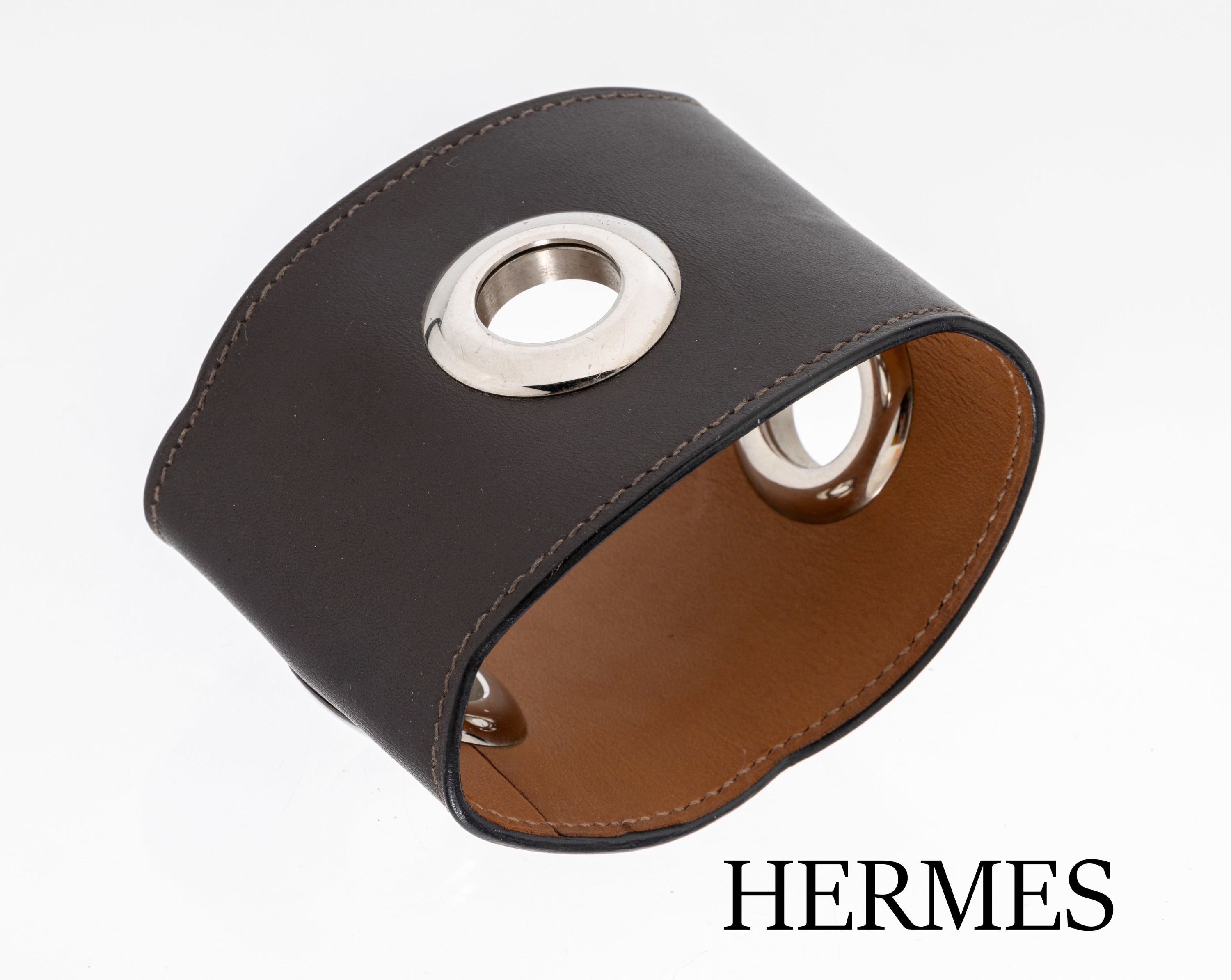 Detail b: HERMES Lederarmreif, dunkelbraunes Leder mit 3 Chromringen, Rand mit leichtem Wellendekor, Durchm. ca. 6.5 cm, B. ca. 5.8 cm, HERMES Paris, Made in ...