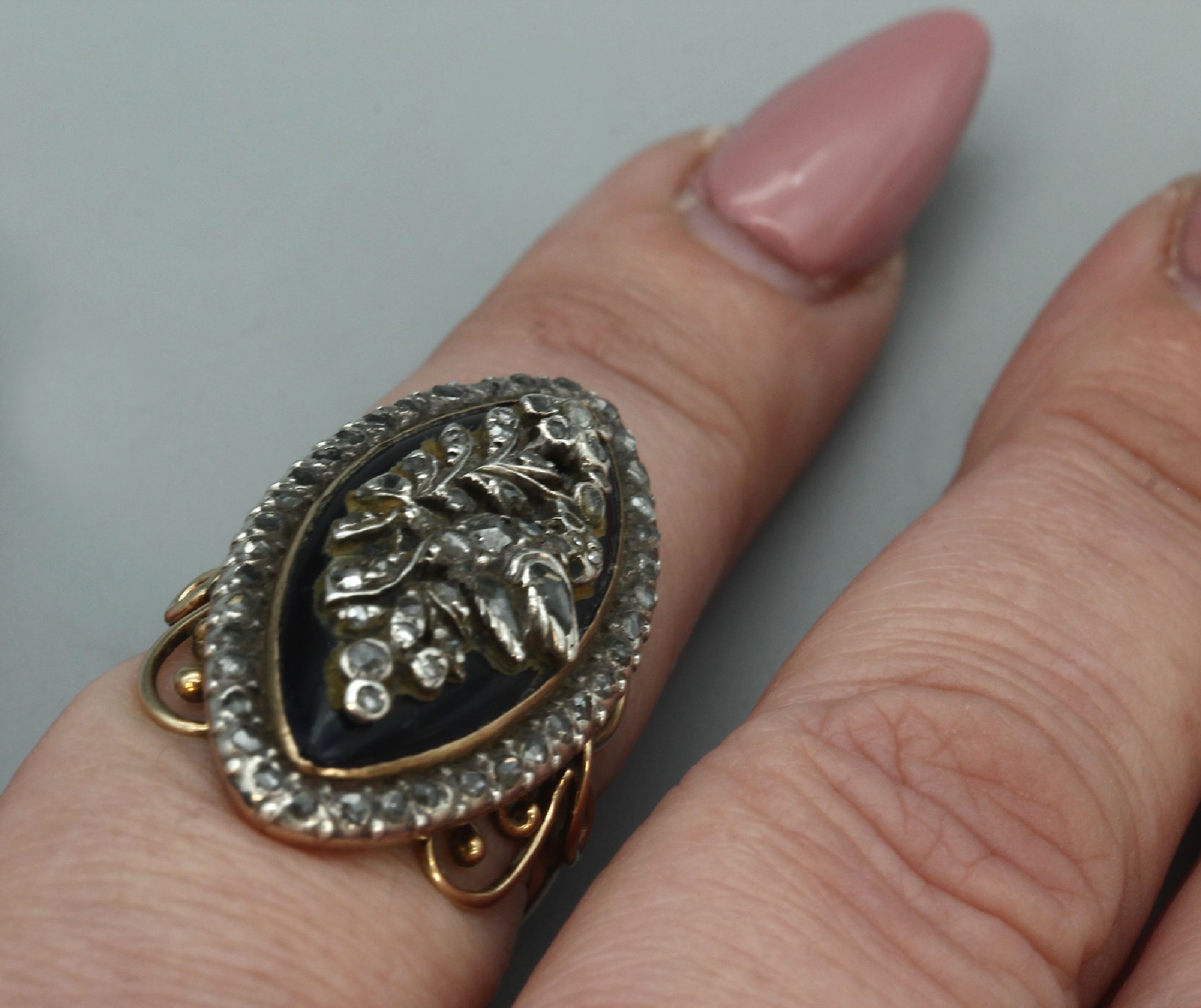 Detail e: 14 kt Gold Diamant-Schiffchenring mit Email, RG 585/000, um 1900, dunkelblau emaill., aufgelegter Blütenzweig mit Diamantrosen, Rahmung mit ...