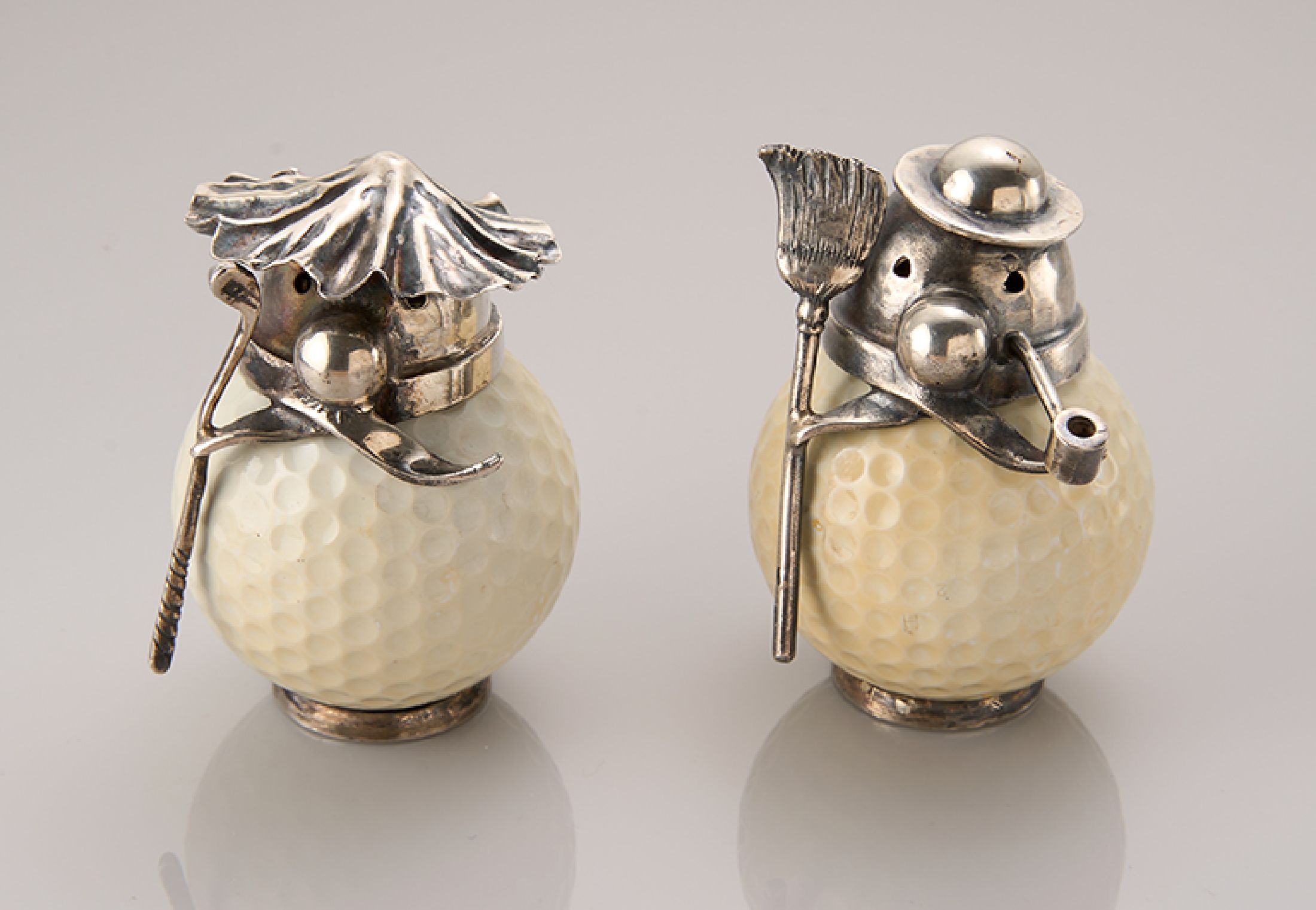 Konvolut 2 skurrile Figuren, Golfbälle mit Silbermontur, 1 x mit Besen, 1 x mit Golfschläger, H ca. 5 cm