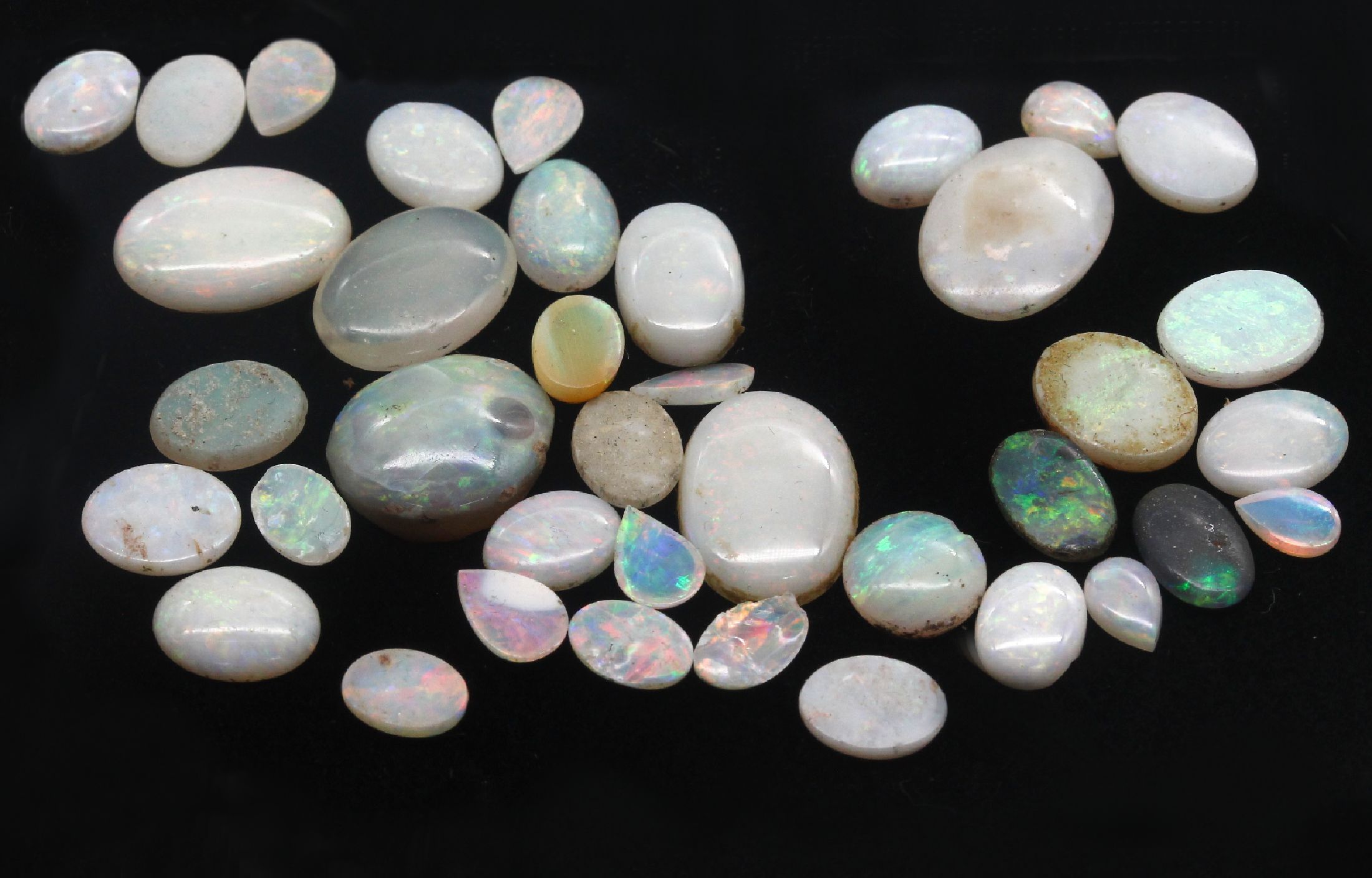 Lot lose Opale, zus. 38.6 ct, in versch. Formen, Farben und Qualitäten, Ausfassware, z.T. besch.