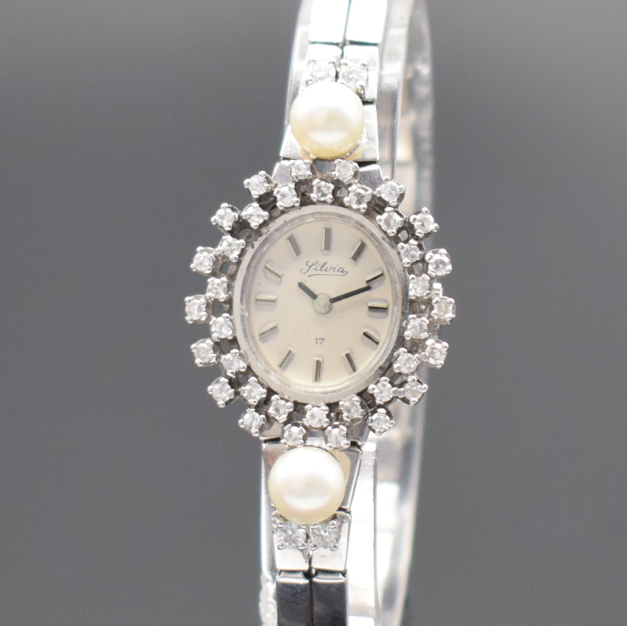 Detail a: SILVIA Damenarmbanduhr in WG 585/000, Schweiz um 1975, Handaufzug, 2-teil. Geh., Boden aufgedr., Lünette und Bandansätze aufw. m. Diamanten und 2 ...