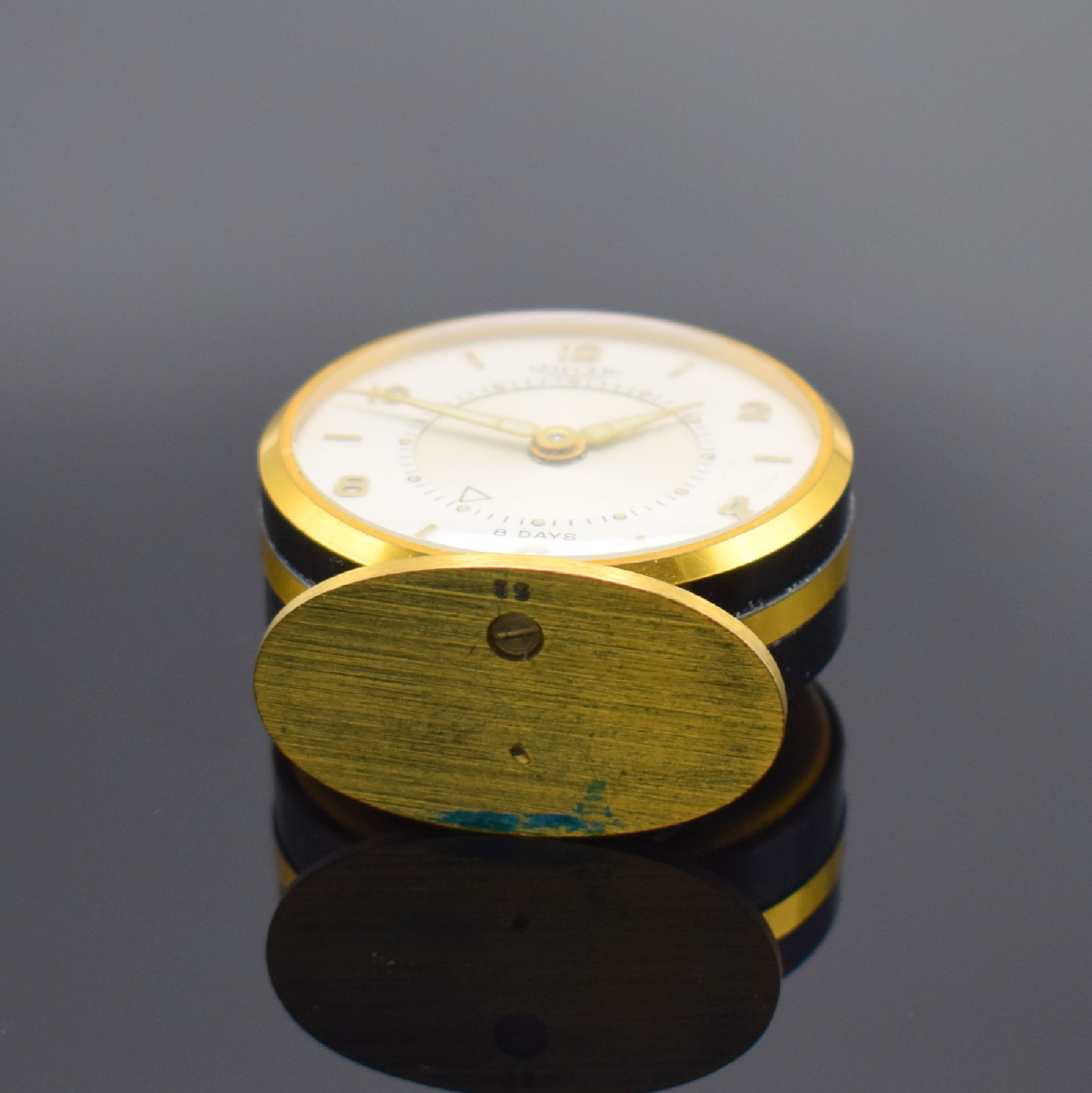 Detail d: JAEGER kleiner Tischwecker mit 8-Tagewerk, Schweiz um 1950, verg., teils schwarz lack. Gehäuse, silb. Zifferbl. m. aufges. gold. Std.-Ind., gold. ...