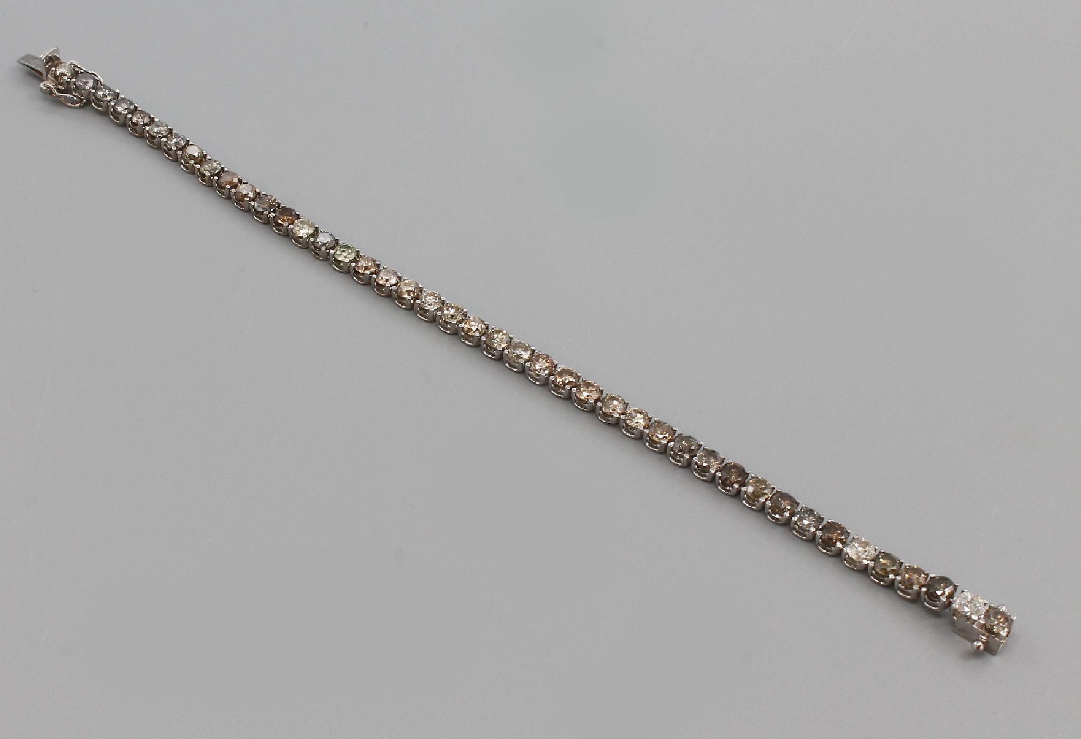 Detail a: 18 kt Gold Brillant-Armband, WG 750/000, 43Brillanten zus. ca. 8.25 ct fancy coloured, L.ca. 18 cm, ca. 11.0 g, Kastenschloß mit Sicherheitsachten