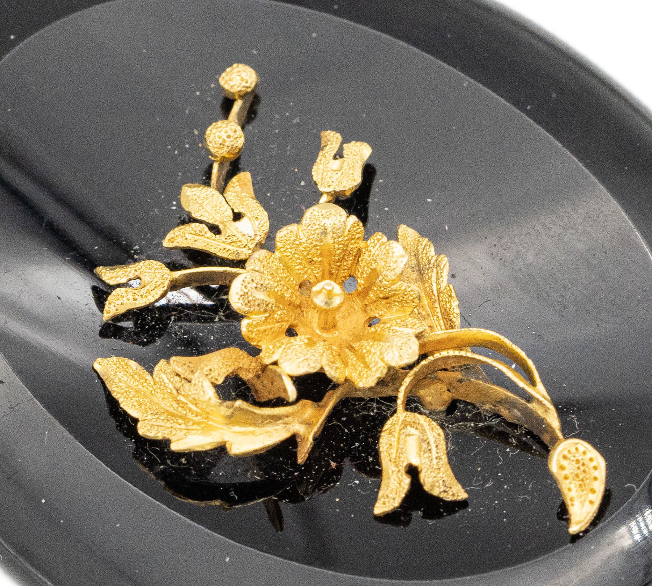 Detail a: Onyx Medaillonanhänger, deutsch um 1840/50, mittig aufgelegtes GG Blütenarrangement, rs. verg., Platz für ein Bild, ca. 6.5 x 4 cm, Tragespuren