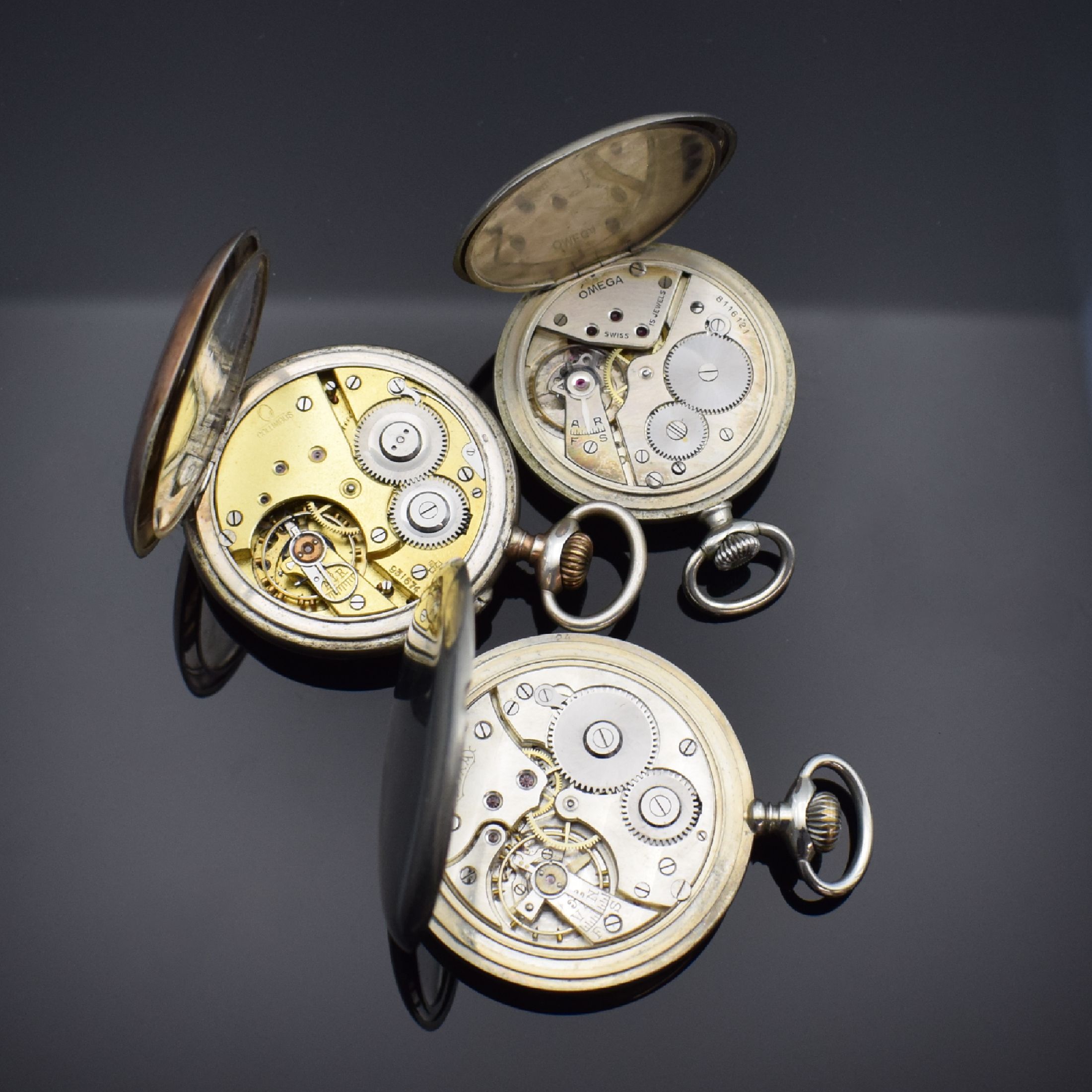 Detail g: OMEGA und 3 weitere offene Taschenuhren, Schweiz / England ca. 1880 - 1940, 1. Omega, Nickelgeh., Emailzifferbl. def., Leuchtzahlen und -zeiger, ...