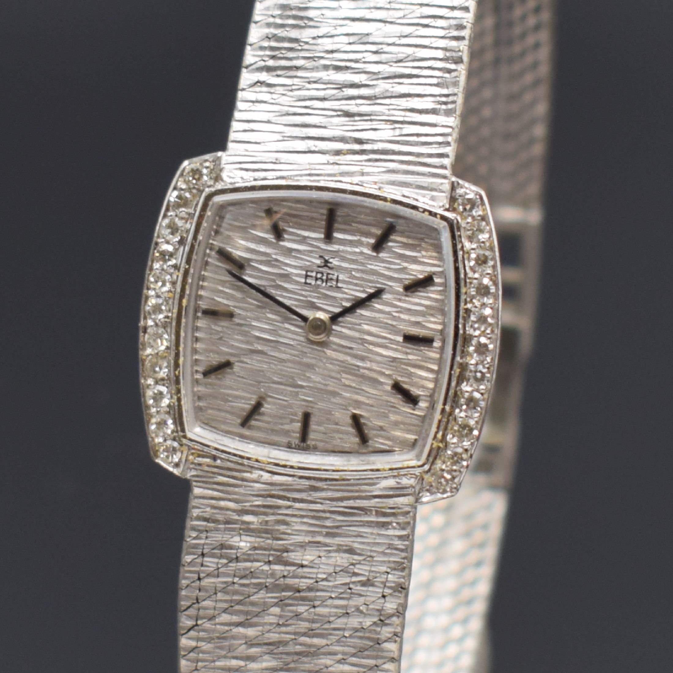 Detail a: EBEL Damenarmbanduhr in WG 750/000, Handaufzug, Schweiz um 1965, Lünette seitl. m. Diamanten bes., Boden aufgedr., Milanaiseband, Strukturzifferbl. ...