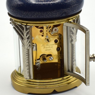 26601968e - MATTHEW NORMAN small 8-days-carriage clock in oriental style, Switzerland around 1985, oval 4-side glazed brass case, blue/gold-painted head with loop, silvered palm-shaped pillars, gold plated and polished movement with lever- escapement, original box and papers enclosed, measures approx. 92 x 60 x 51 mm, hairspring has to be replaced, needs to be overhauled, condition 3