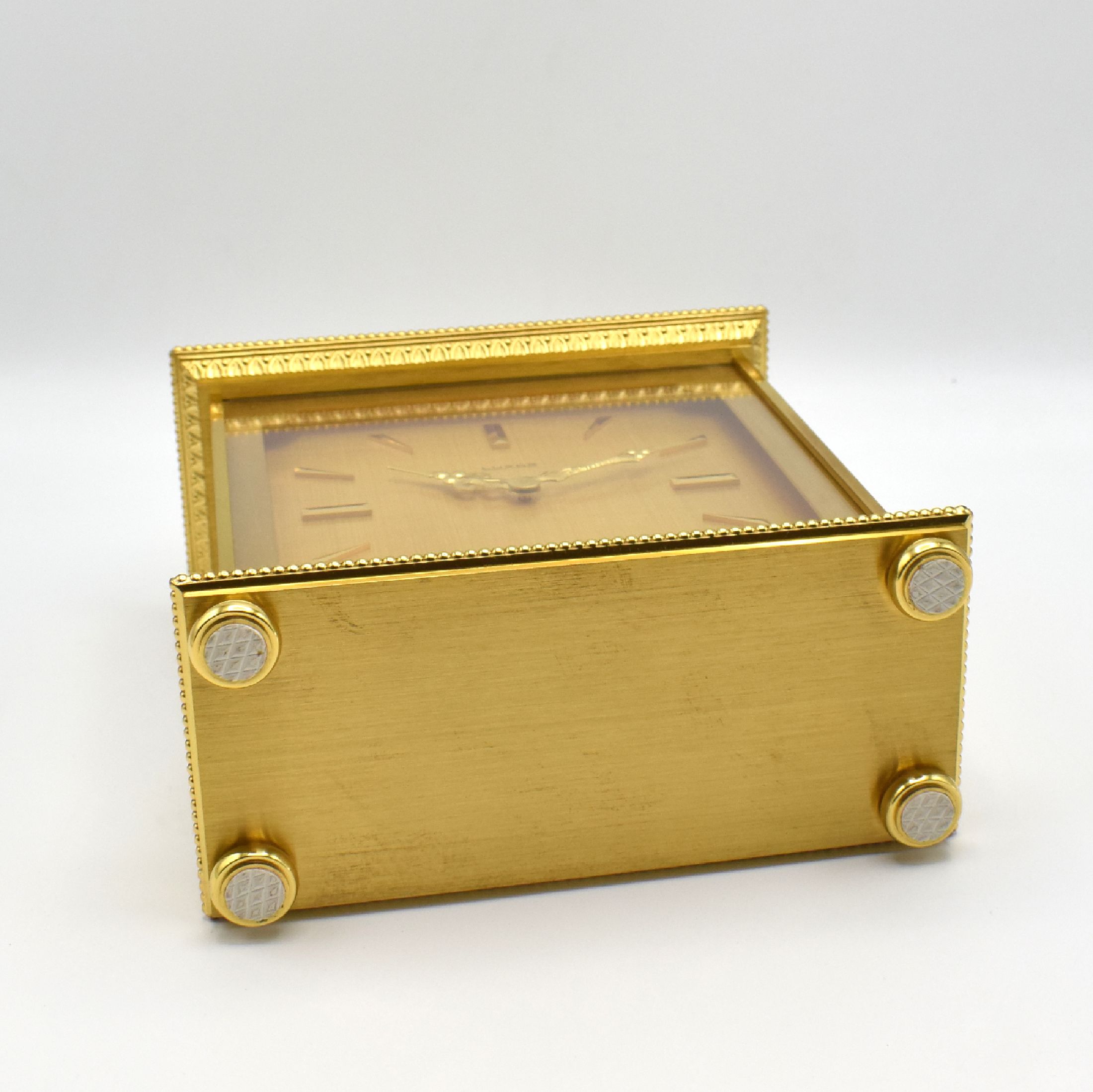 Detail e: LUXOR hochwertige Tischuhr mit Schlagwerk, Schweiz um 1980, quadratisches Messinggeh. auf 4 Füßen, gold. Zifferbl., aufges. Std.- Ind., gold. ...