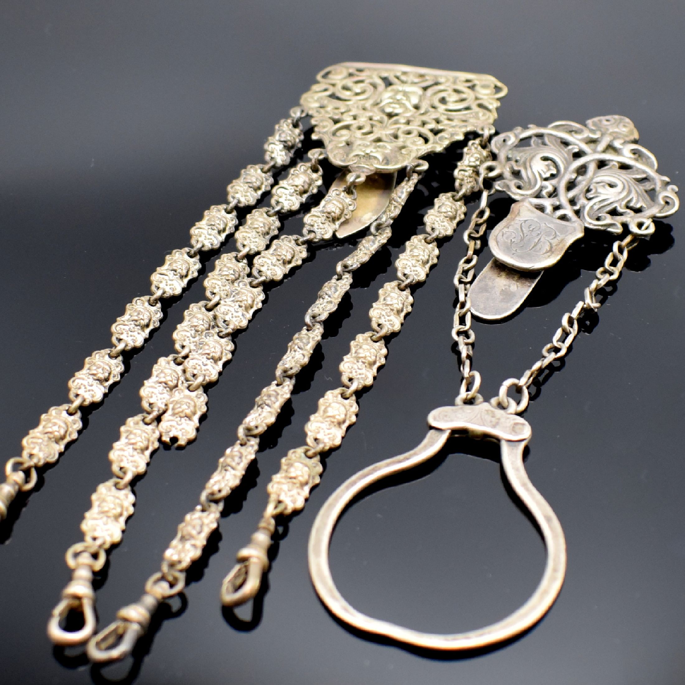 Detail b: 3 Ketten und 2 Chatelaines, um 1830-1850 (teils englisch), 2 Ketten aus Haar (besch.) m. Karabiner und 1x Federring, 1 vers. Kette m. Karabiner und ...