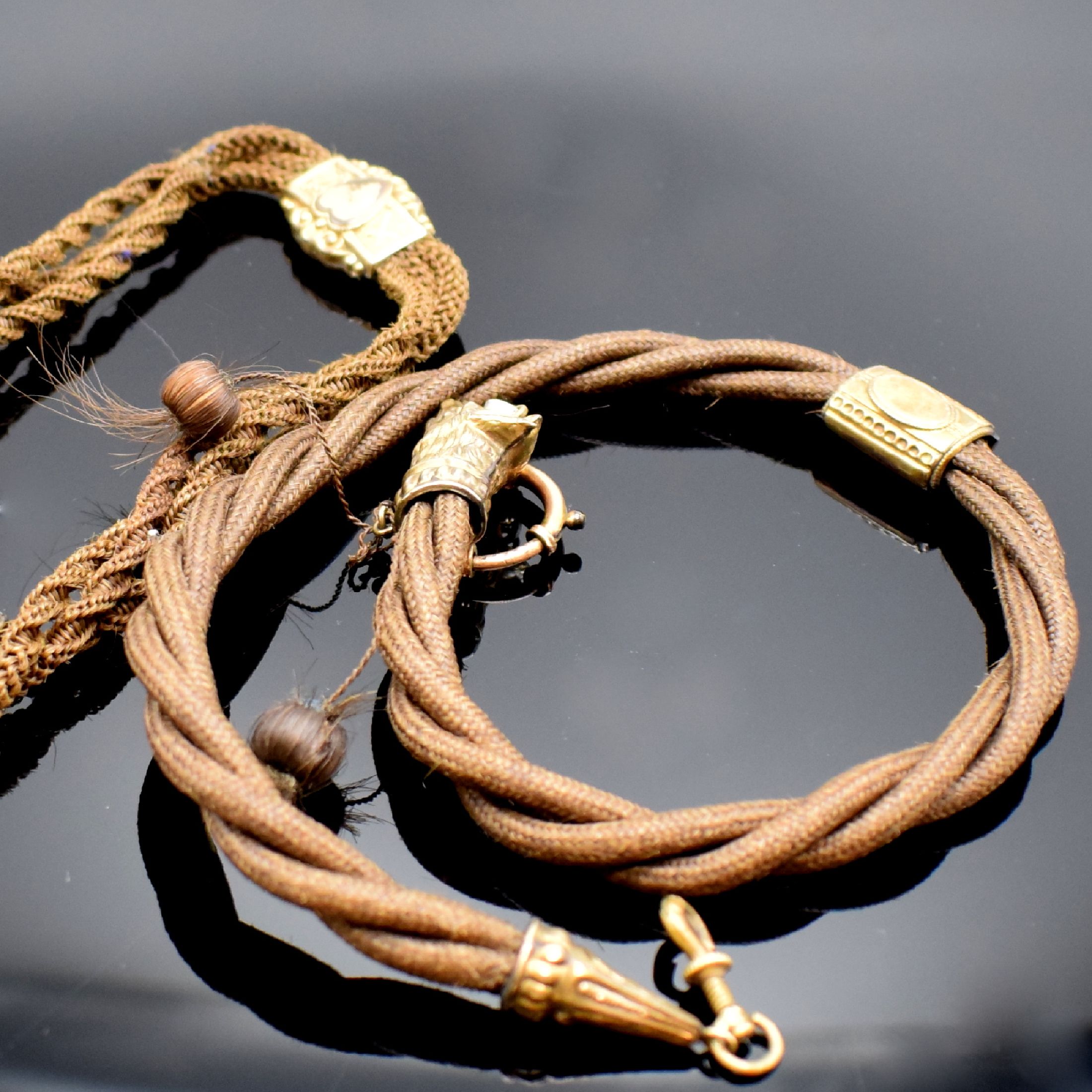 Detail d: 3 Ketten und 2 Chatelaines, um 1830-1850 (teils englisch), 2 Ketten aus Haar (besch.) m. Karabiner und 1x Federring, 1 vers. Kette m. Karabiner und ...