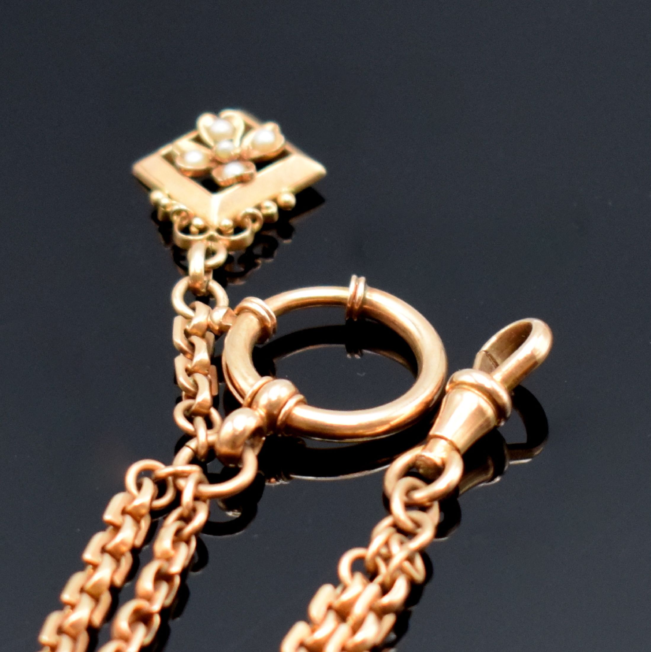 Detail a: Taschenuhrkette in RG 585/000, mit Karabiner, Federring und Anhänger in Form einer Blüte m. kleinen Perlen, L. ca. 18 cm, Gew. ca. 13g, in ...
