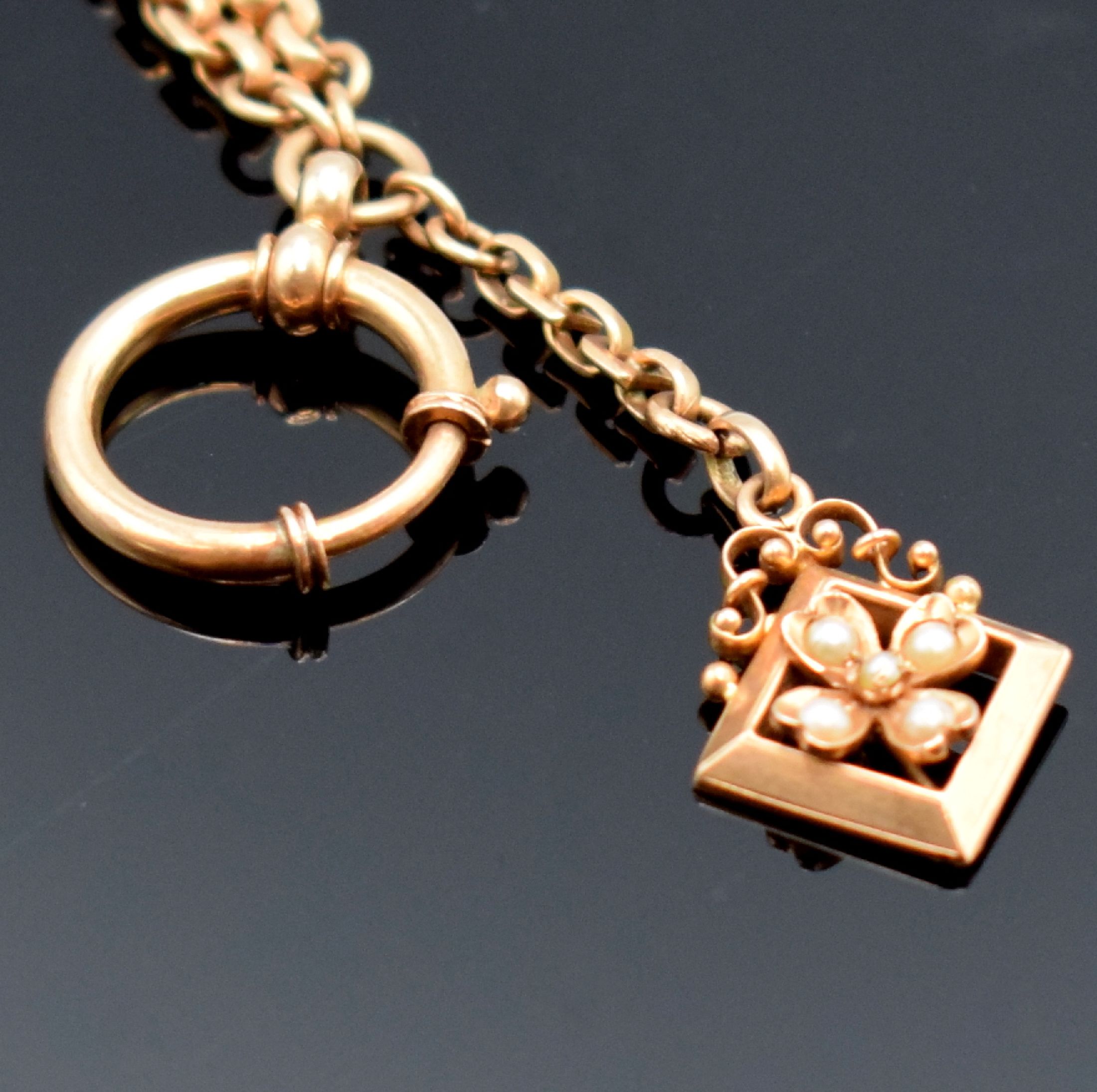 Detail b: Taschenuhrkette in RG 585/000, mit Karabiner, Federring und Anhänger in Form einer Blüte m. kleinen Perlen, L. ca. 18 cm, Gew. ca. 13g, in ...