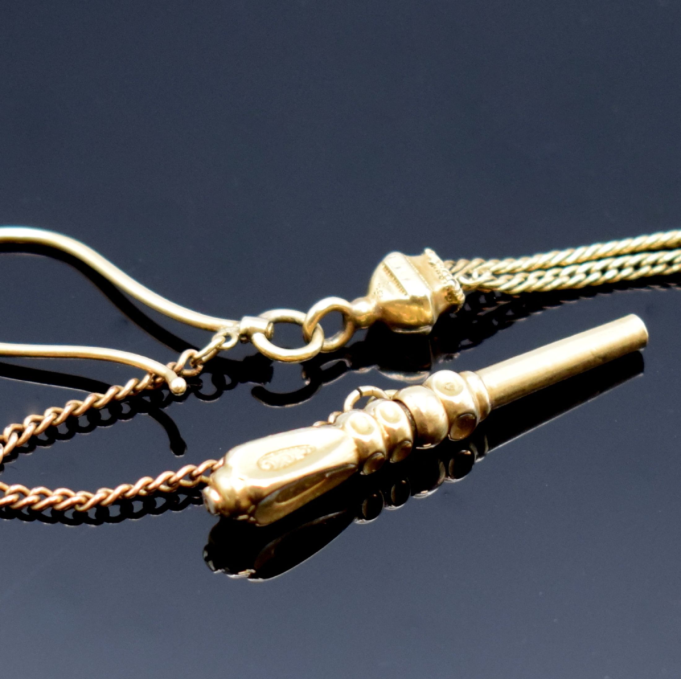 Detail b: Taschenuhrkette in GG 585/000, m. Taschenuhrschlüssel (m. Goldauflage), Haken und Schieber (defekt), L. ca. 36,5 cm, Gesamtgew. ca. 15g, Nutzspuren