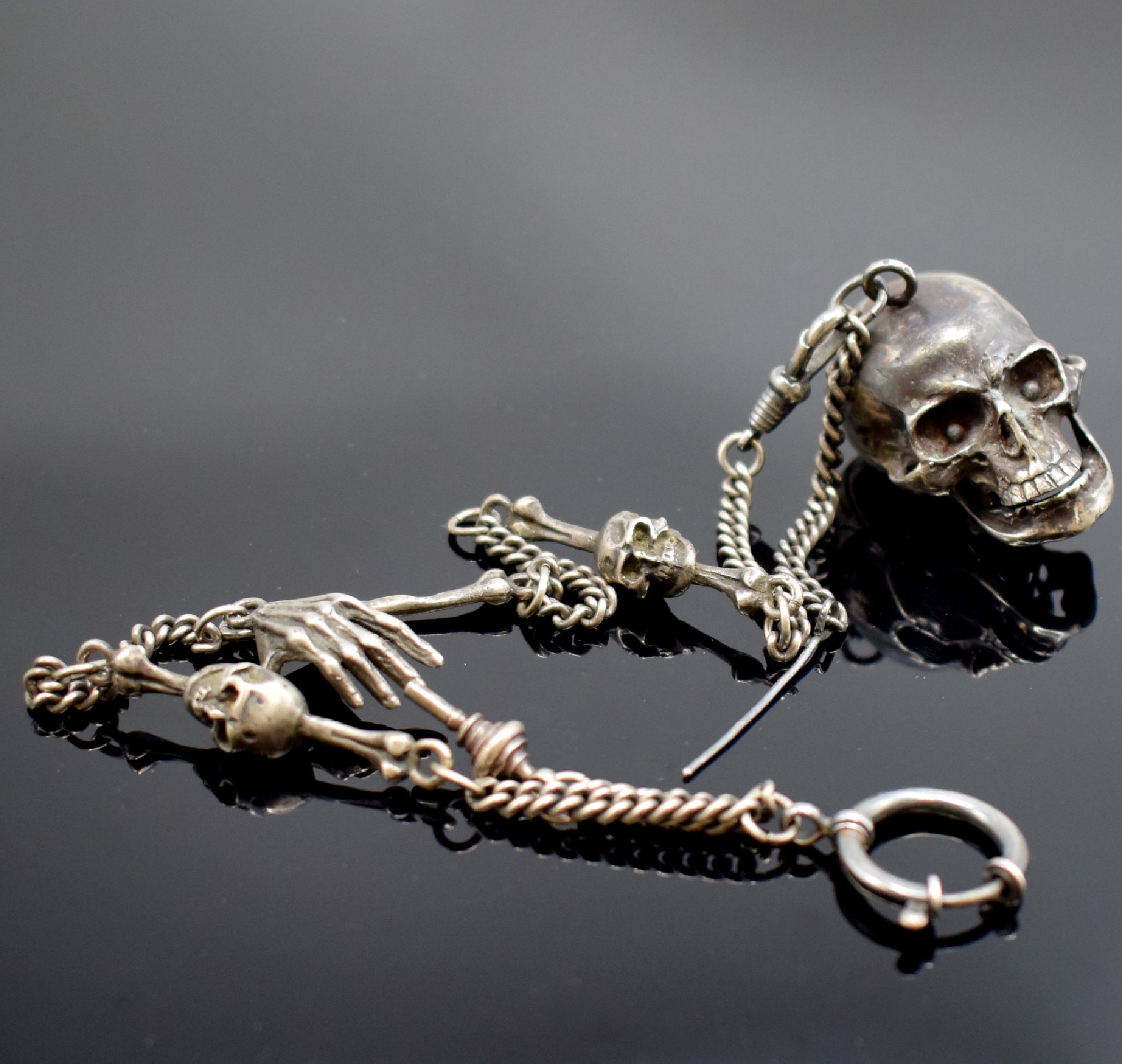 Totenkopfuhr in Silber mit Kette, 2. Hälfte 20 Jhd., aufklappbares Gehäuse, passende Kette m. Todessymbolik, integr. Ankerwerk m. 15 St. früher, ...