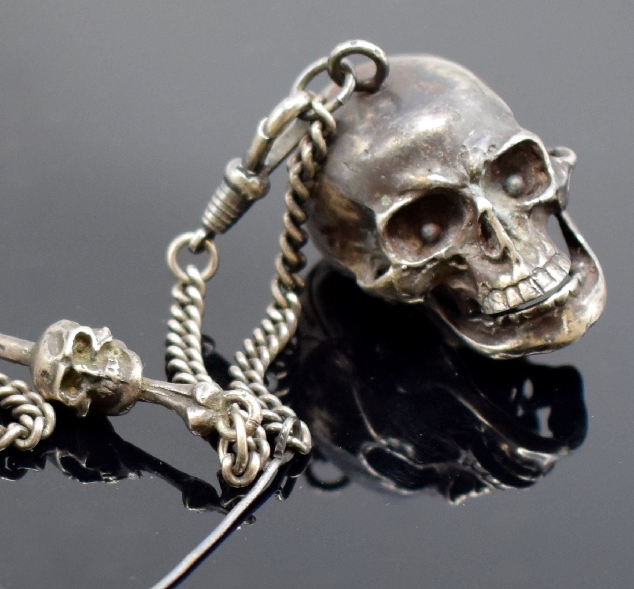 Detail a: Totenkopfuhr in Silber mit Kette, 2. Hälfte 20 Jhd., aufklappbares Gehäuse, passende Kette m. Todessymbolik, integr. Ankerwerk m. 15 St. früher, ...