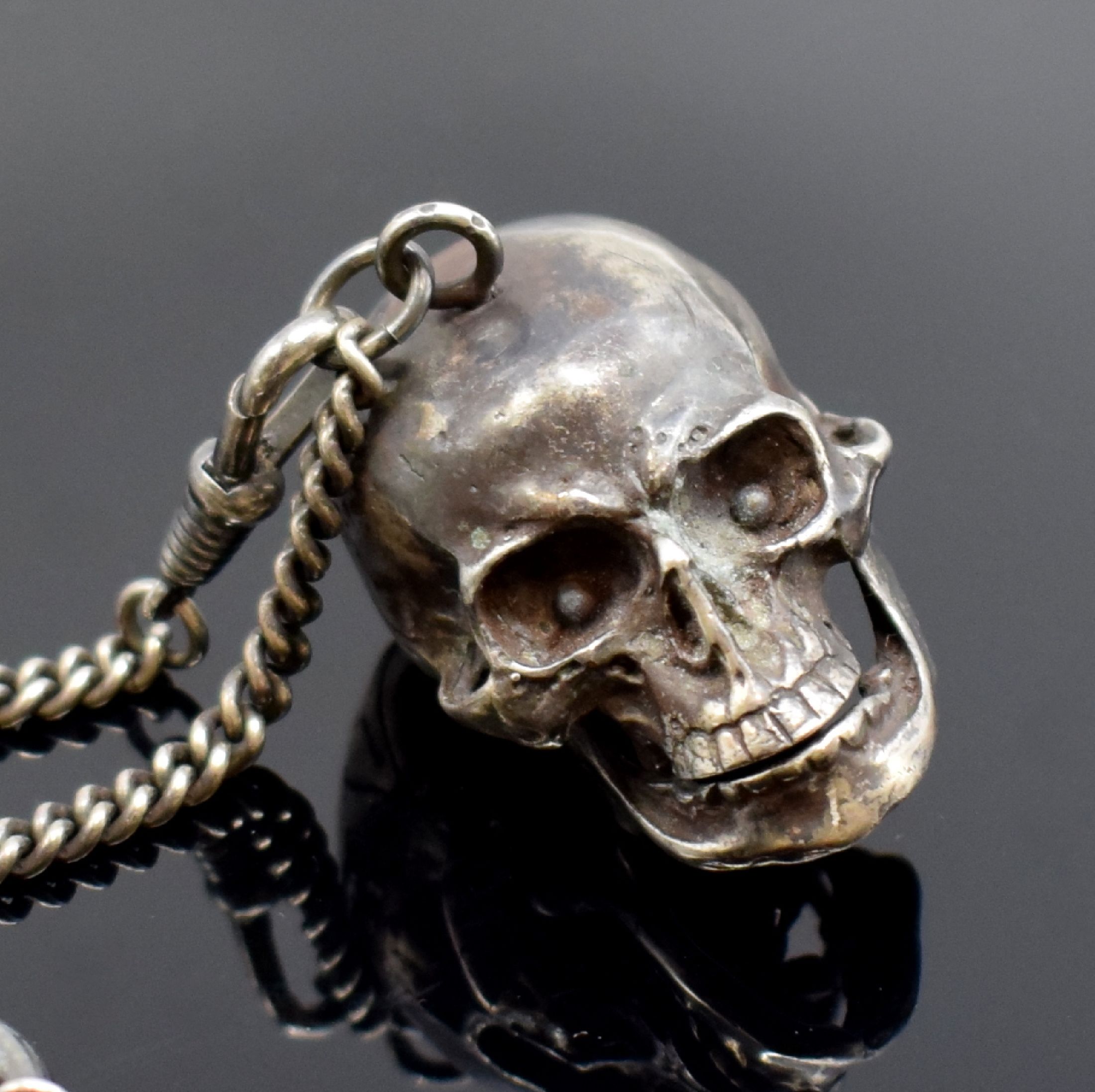 Detail c: Totenkopfuhr in Silber mit Kette, 2. Hälfte 20 Jhd., aufklappbares Gehäuse, passende Kette m. Todessymbolik, integr. Ankerwerk m. 15 St. früher, ...