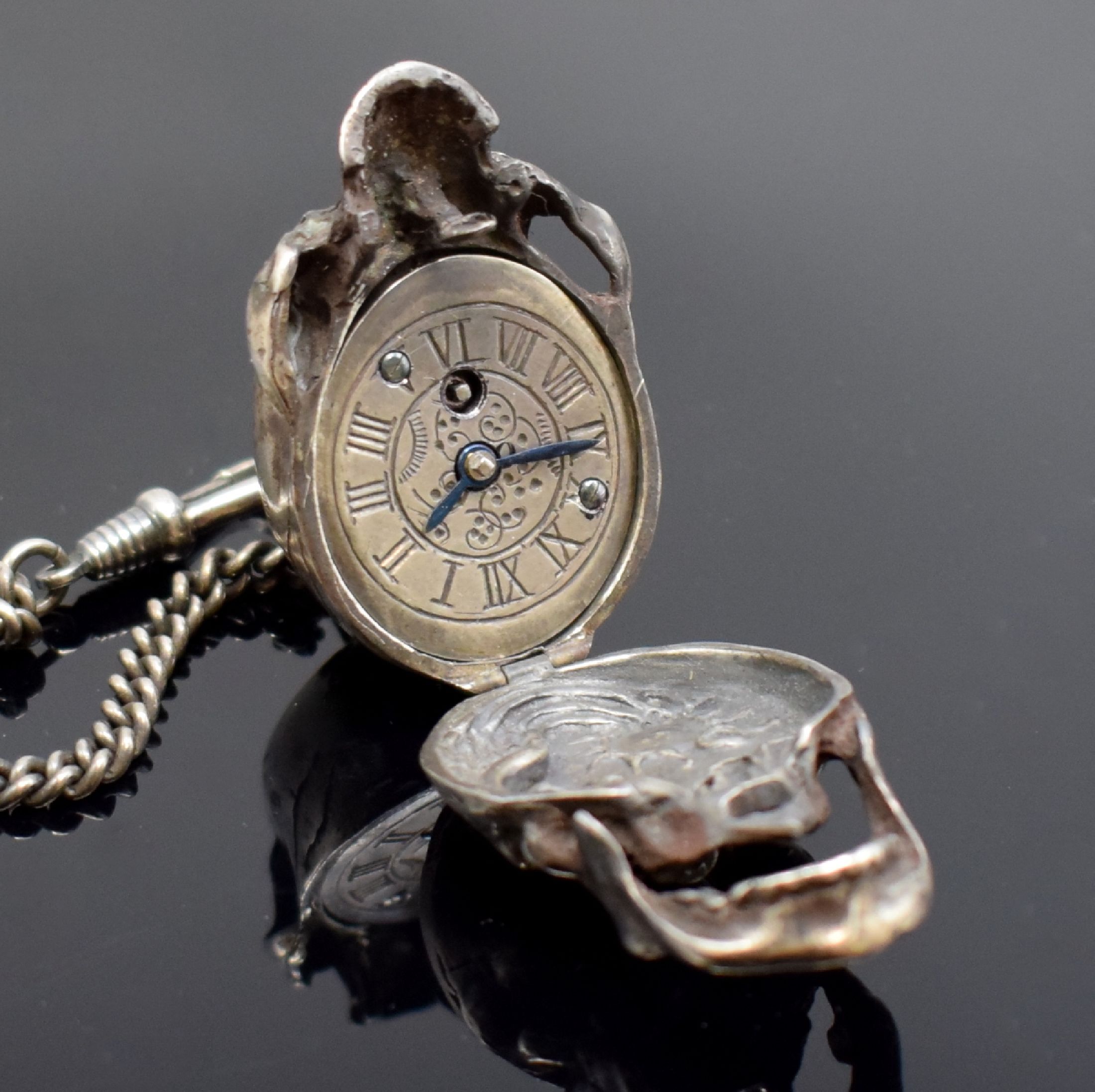 Detail d: Totenkopfuhr in Silber mit Kette, 2. Hälfte 20 Jhd., aufklappbares Gehäuse, passende Kette m. Todessymbolik, integr. Ankerwerk m. 15 St. früher, ...
