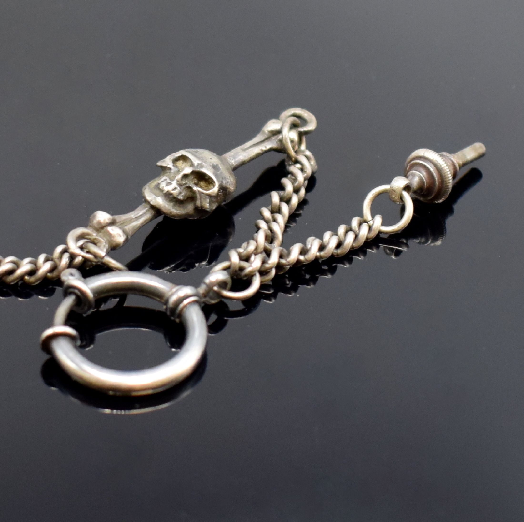 Detail e: Totenkopfuhr in Silber mit Kette, 2. Hälfte 20 Jhd., aufklappbares Gehäuse, passende Kette m. Todessymbolik, integr. Ankerwerk m. 15 St. früher, ...