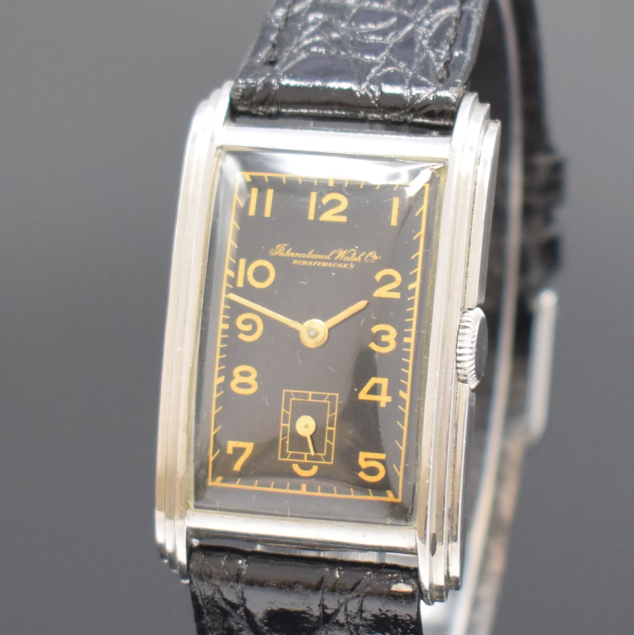 Detail a: IWC rechteckige Herrenarmbanduhr mit Kaliber 87 in Stahl, Schweiz um 1937, Handaufzug, 2-teil. gestuft. Geh., Boden aufgedr., schwarzes Zifferbl. m. ...