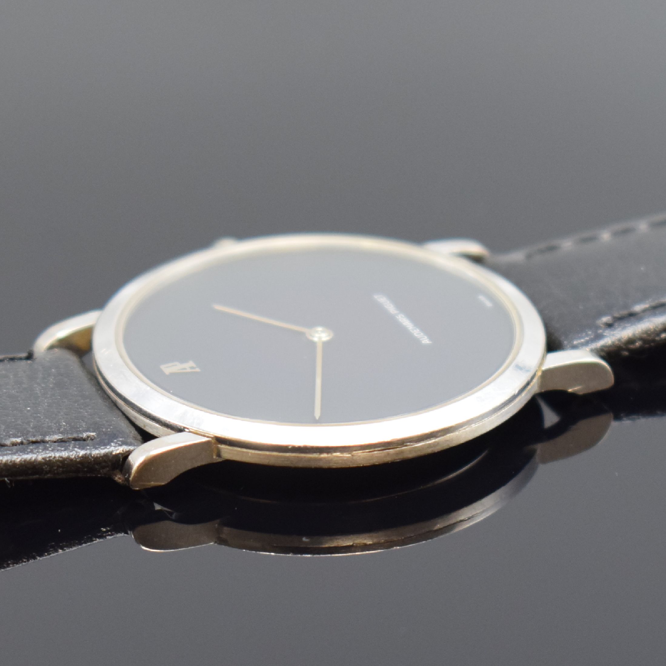 Detail c: AUDEMARS PIGUET Herrenarmbanduhr in WG 750/000, Schweiz um 1980, Handaufzug, 3-teil. Geh., Boden und Glasrand aufgedr., schwarzes Zifferbl., silb. ...