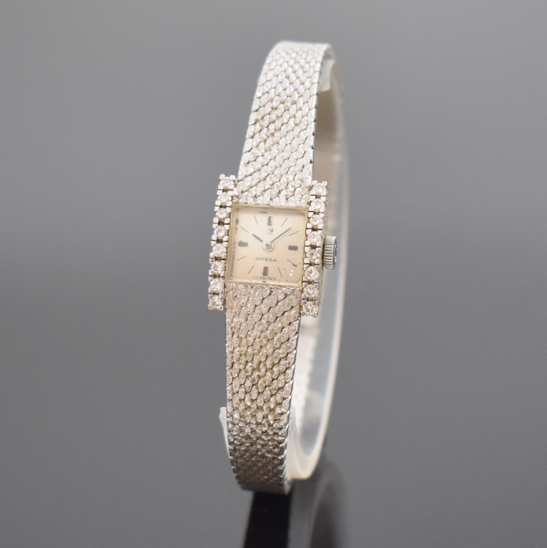 OMEGA Damenarmbanduhr in WG 750/000 Referenz 8104, Schweiz um 1968, Handaufzug, 2-teil. Geh. seitl. m. Diamanten bes., Boden aufgedr., Milanaiseband, ...
