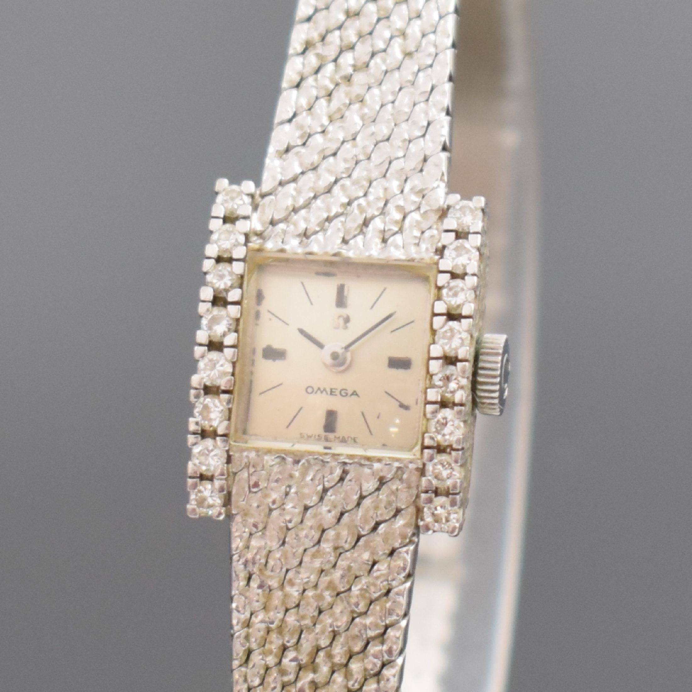 Detail a: OMEGA Damenarmbanduhr in WG 750/000 Referenz 8104, Schweiz um 1968, Handaufzug, 2-teil. Geh. seitl. m. Diamanten bes., Boden aufgedr., Milanaiseband, ...