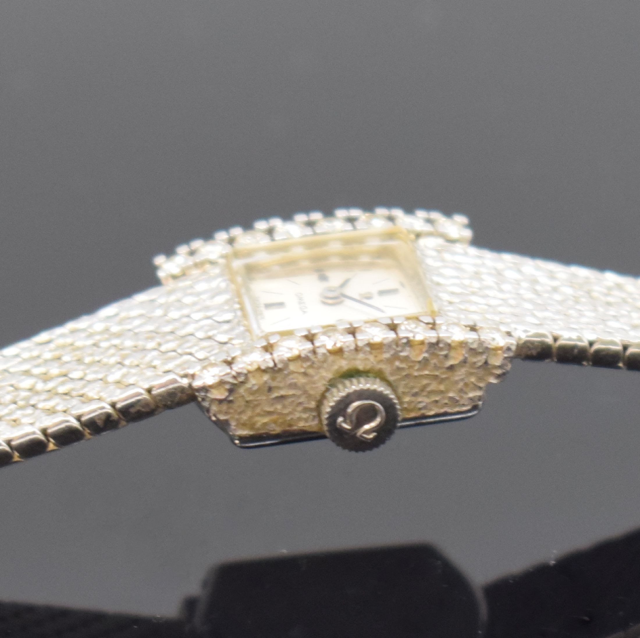 Detail d: OMEGA Damenarmbanduhr in WG 750/000 Referenz 8104, Schweiz um 1968, Handaufzug, 2-teil. Geh. seitl. m. Diamanten bes., Boden aufgedr., Milanaiseband, ...