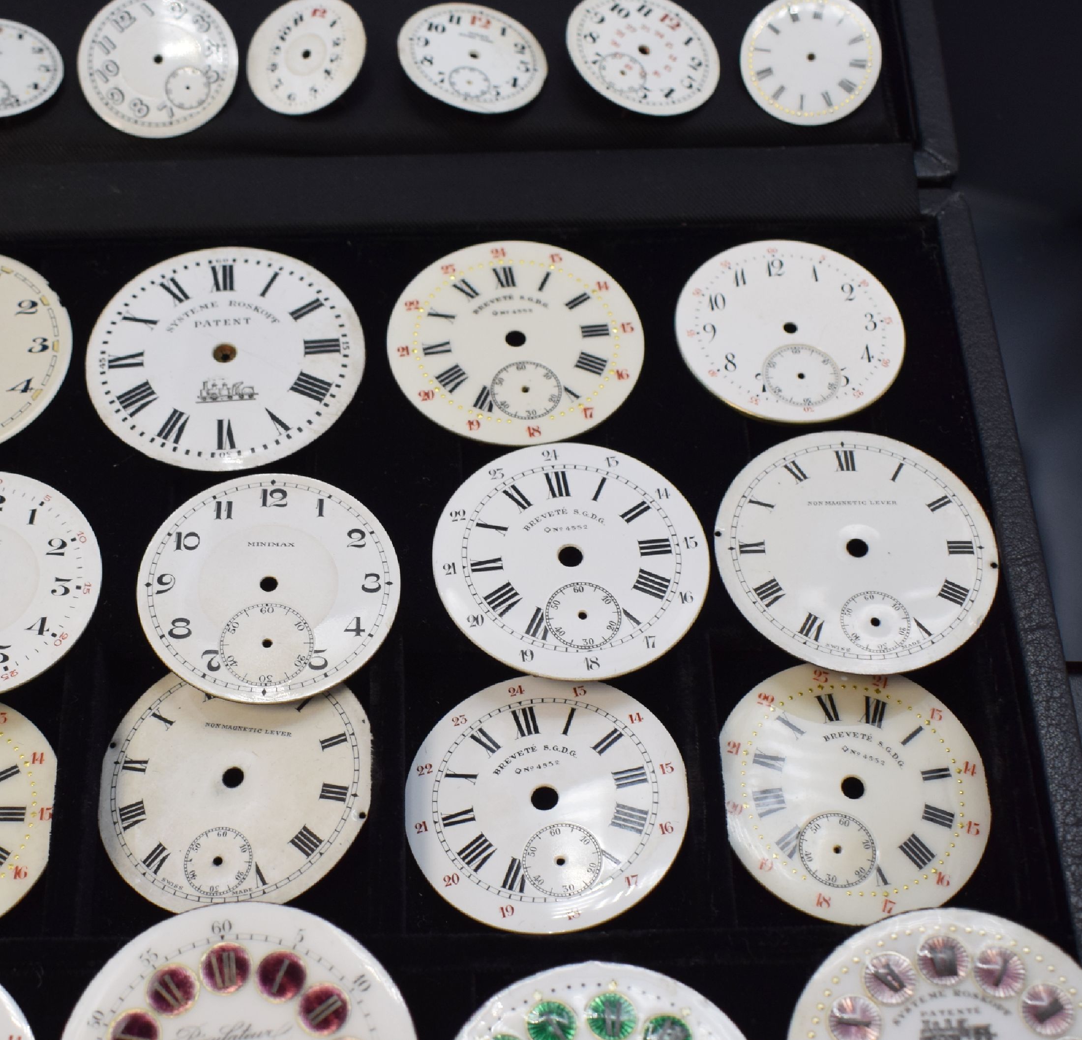 Detail d: 46 unbenutzte Taschenuhr-Zifferblätter, Schweiz um 1900, überwiegend in Email u. für Herrenuhren, m. röm. u. arab. Zahlen, teils m. aufwendigen ...