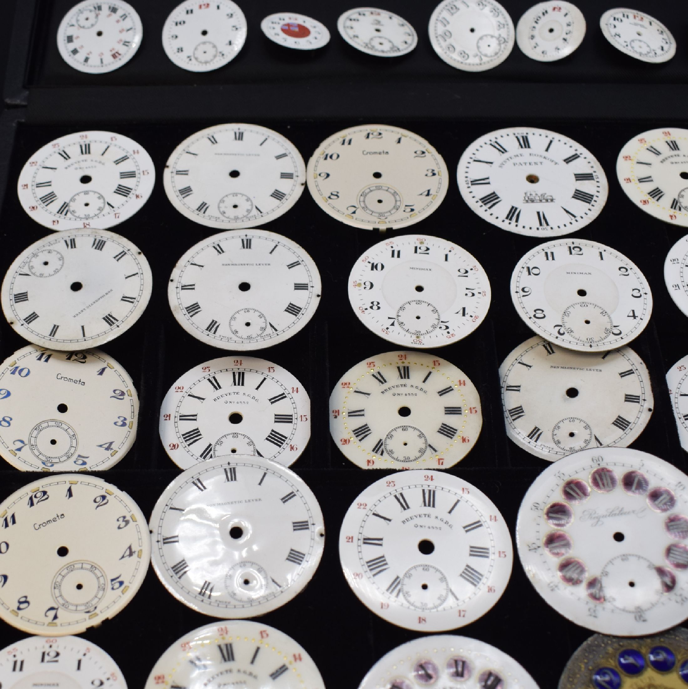 Detail e: 46 unbenutzte Taschenuhr-Zifferblätter, Schweiz um 1900, überwiegend in Email u. für Herrenuhren, m. röm. u. arab. Zahlen, teils m. aufwendigen ...