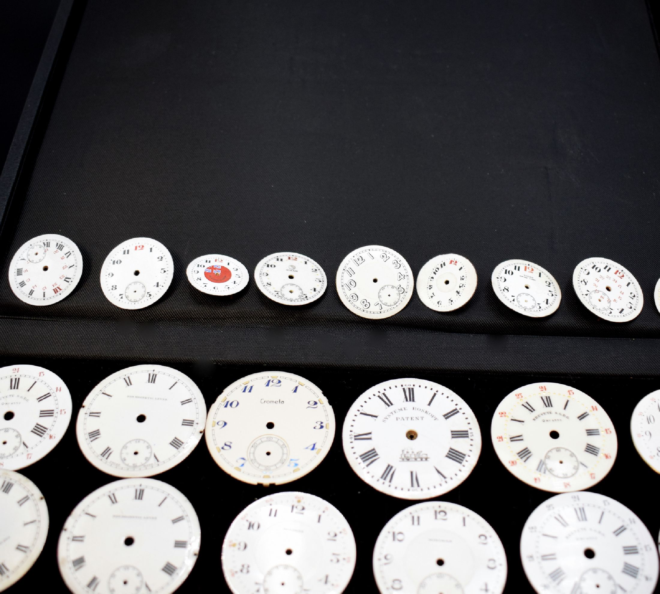 Detail f: 46 unbenutzte Taschenuhr-Zifferblätter, Schweiz um 1900, überwiegend in Email u. für Herrenuhren, m. röm. u. arab. Zahlen, teils m. aufwendigen ...