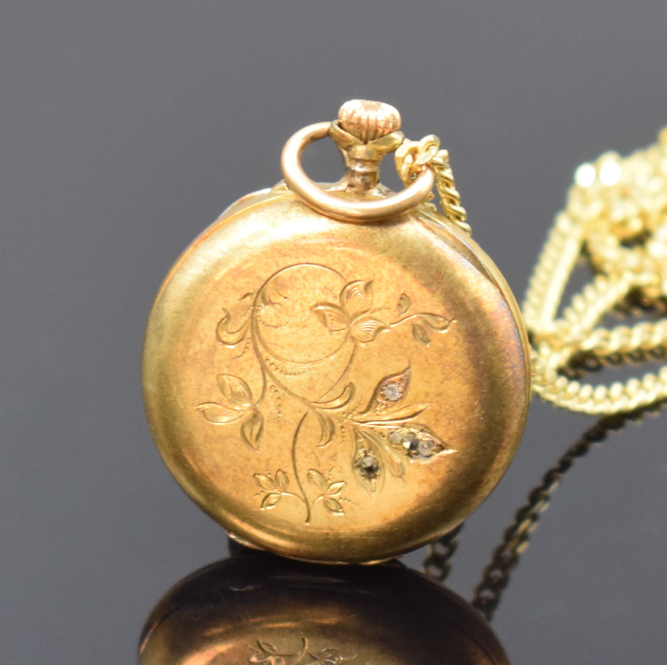 Detail a: Offene Damentaschenuhr in RG 585/000 mit Kette in GG 585/000, Schweiz um 1890, Kette sp., Metallcuvette, Emailzifferbl. m. röm. Zahlen, gold. ...