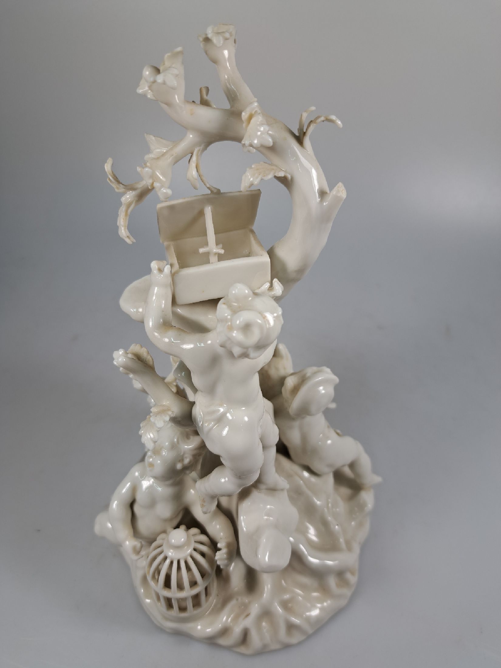 Detail e: 3 Porzellanfiguren, Nymphenburg, 20. Jh., weiß, 4 Amoretten im Baum mit verschiedenen Attributen, H. ca. 22cm, Allegorie auf den Winter, H. ca. ...