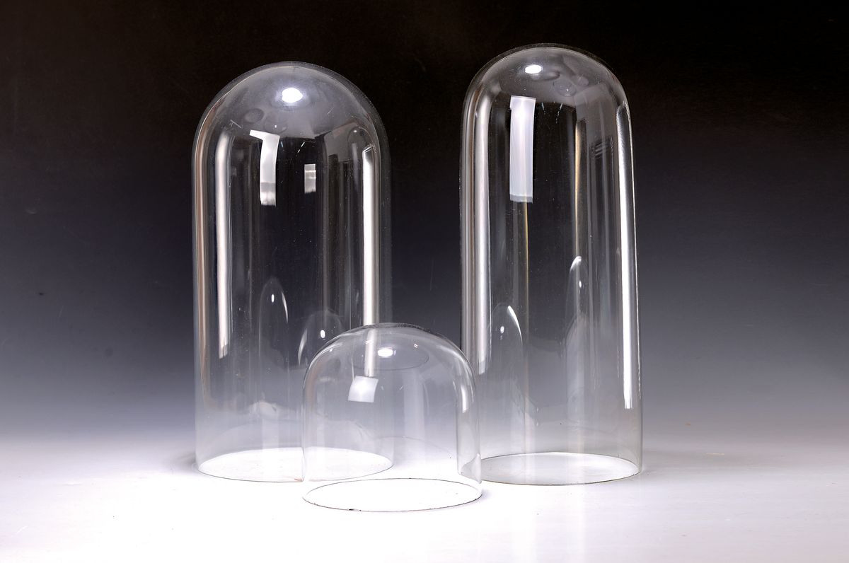 Drei Glasdome/-hauben, 20. Jh., farbloses Glas, H. ca. 39.5-40.5 cm/ 15 cm, D. ca. 18.5/17/16 cm, kleiner Dom am Rand l. best., dieser vermutlich ...