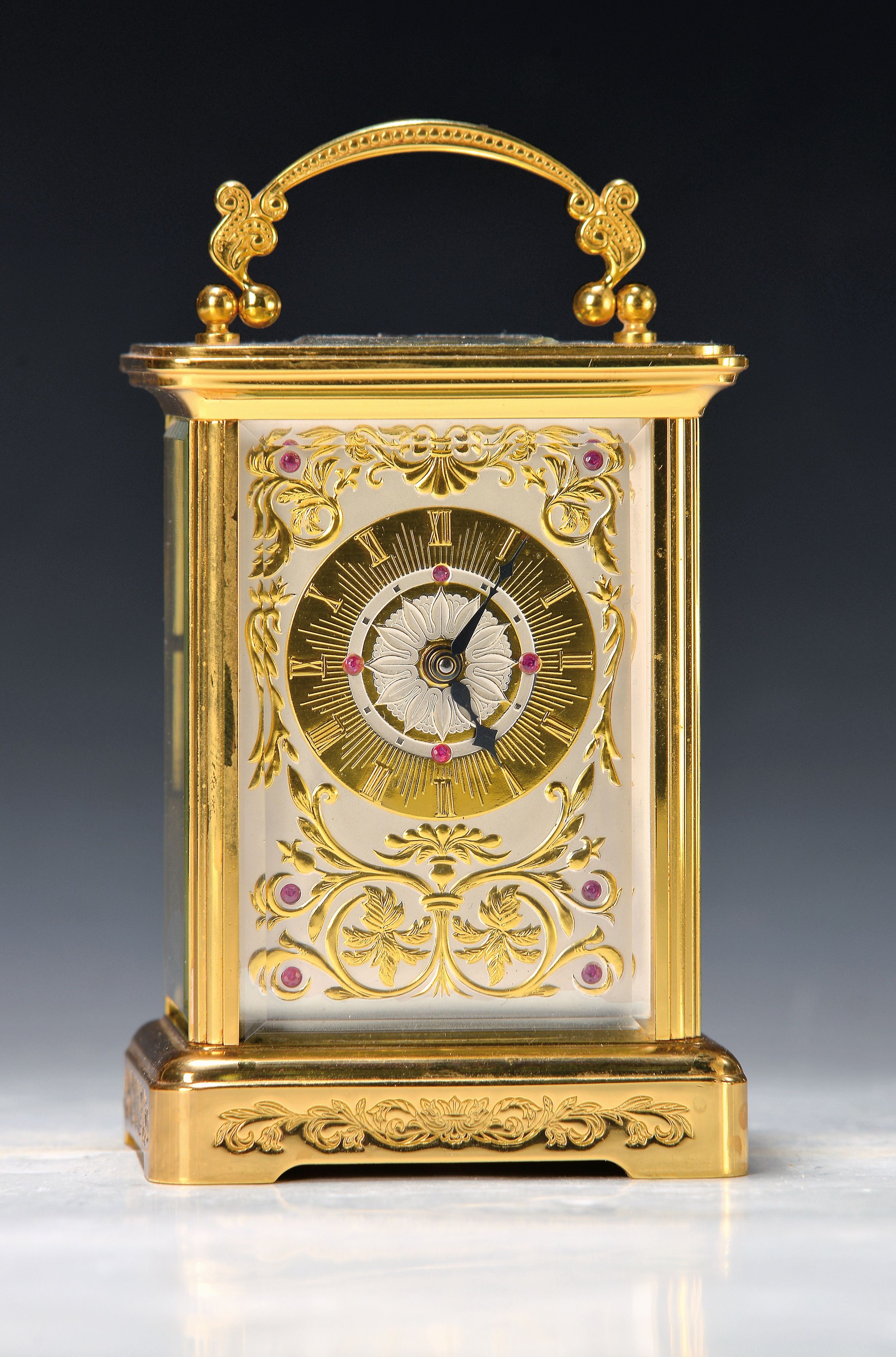Tischuhr Igor Carl Fabergé, um 1930/40, vergoldetes Messinggehäuse in der Corniche Form, z.T. graviert, seltene Henkelform, allseitig facett. ...