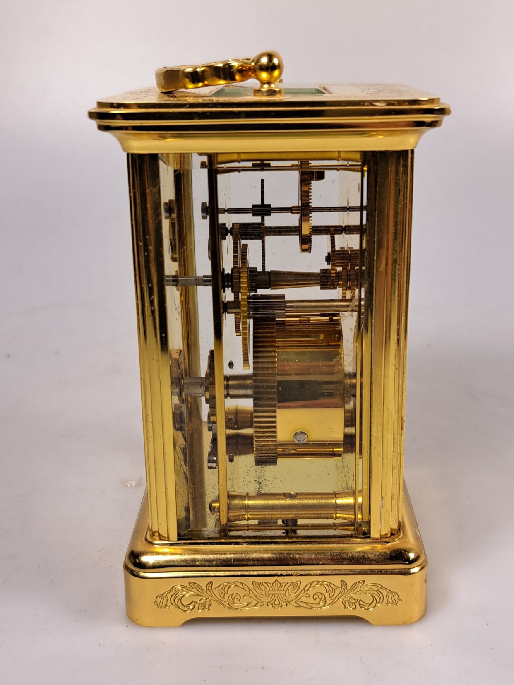 Detail e: Tischuhr Igor Carl Fabergé, um 1930/40, vergoldetes Messinggehäuse in der Corniche Form, z.T. graviert, seltene Henkelform, allseitig facett. ...
