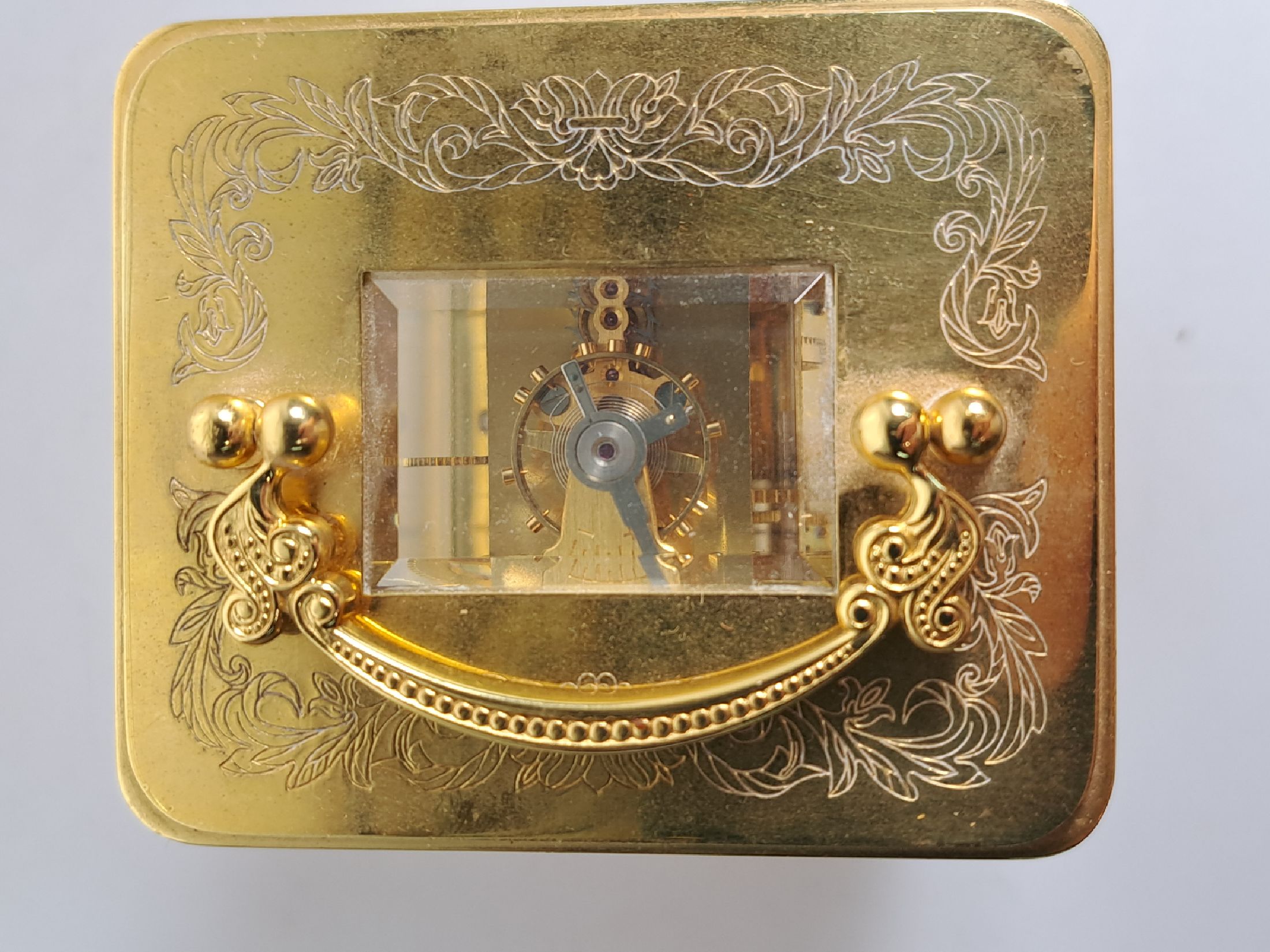 Detail f: Tischuhr Igor Carl Fabergé, um 1930/40, vergoldetes Messinggehäuse in der Corniche Form, z.T. graviert, seltene Henkelform, allseitig facett. ...