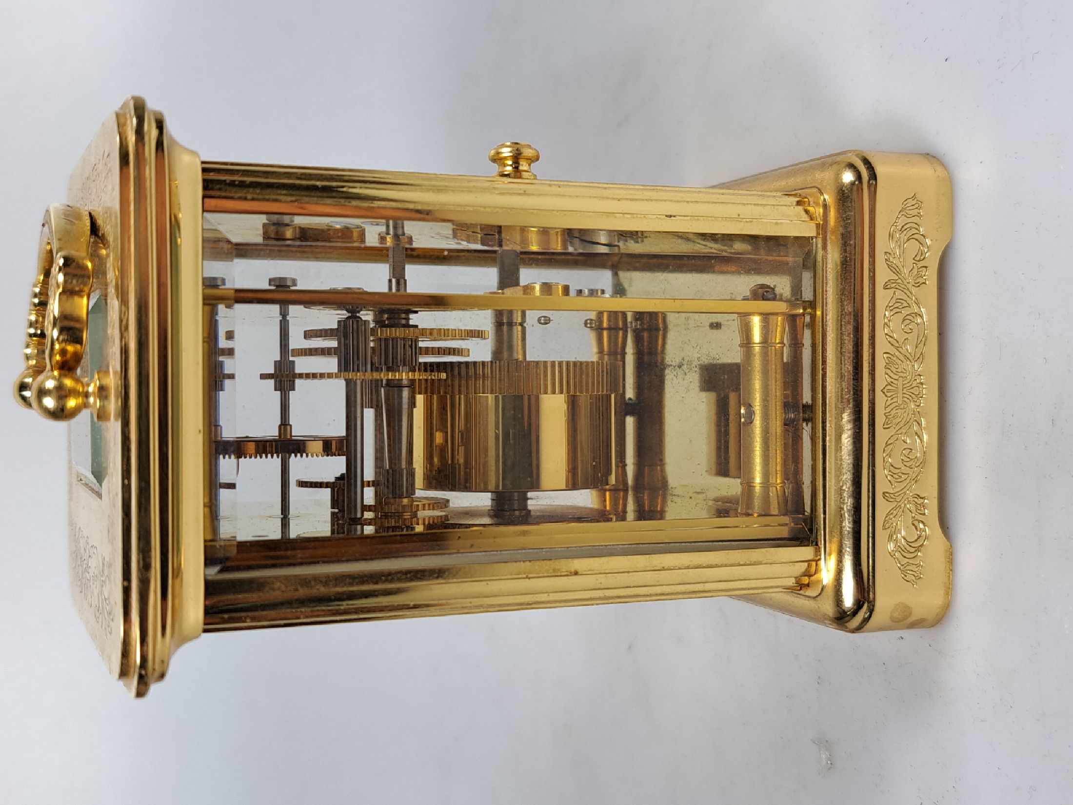 Detail g: Tischuhr Igor Carl Fabergé, um 1930/40, vergoldetes Messinggehäuse in der Corniche Form, z.T. graviert, seltene Henkelform, allseitig facett. ...