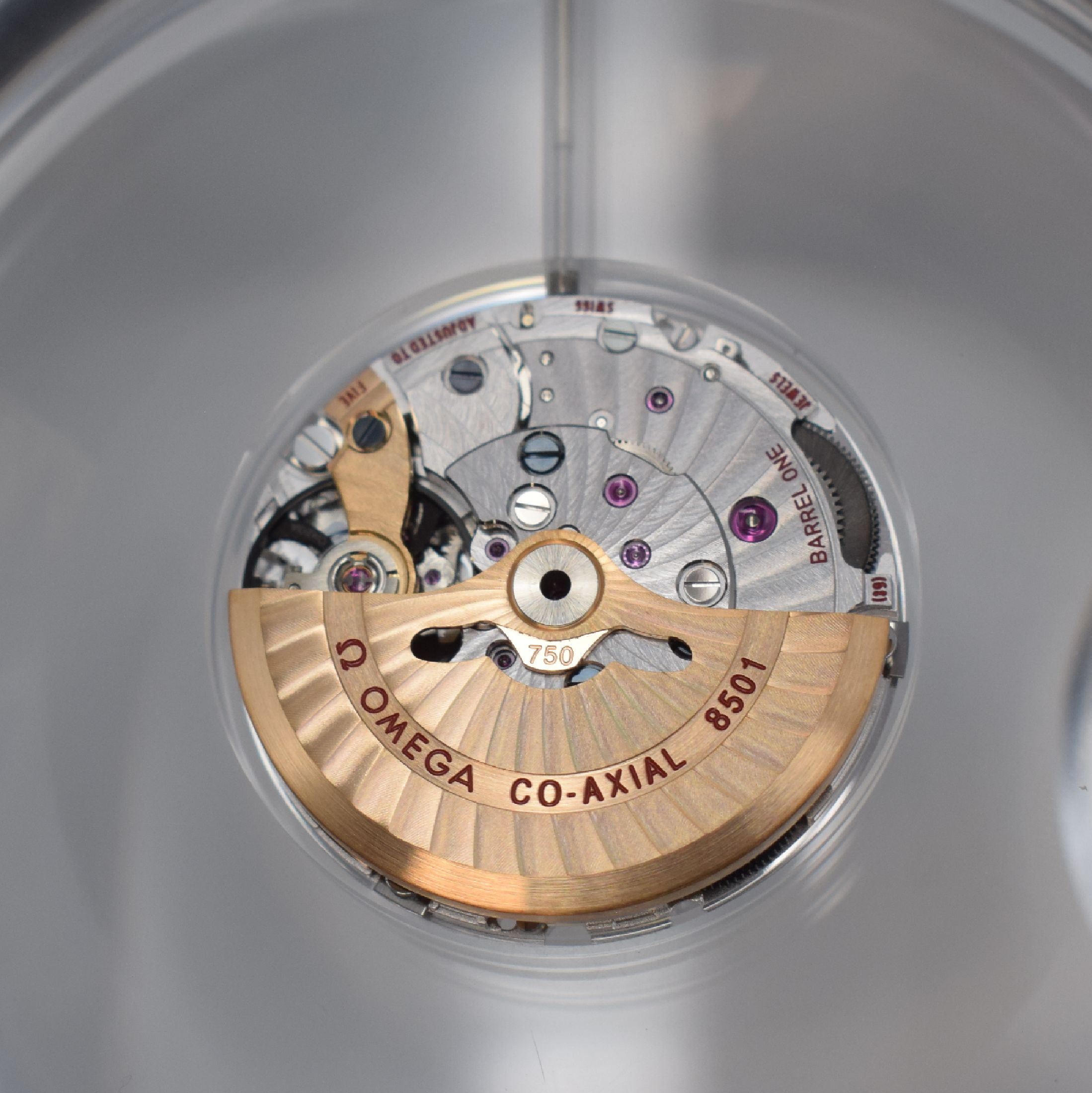 Detail a: OMEGA Kaliber 8501 seltenes Schauwerk mit Rotor und Unruhbrücke in Gold 750/000, Schweiz um 2020, 2-Tlg. Kugelförmiges Acryl- Geh. m. Lupen-Effekt, ...